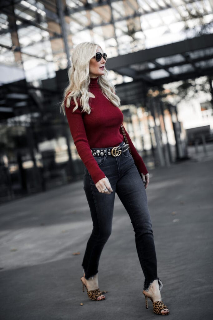 Dallas blonde woman wearing Gucci belt and red turtleneck sweater
