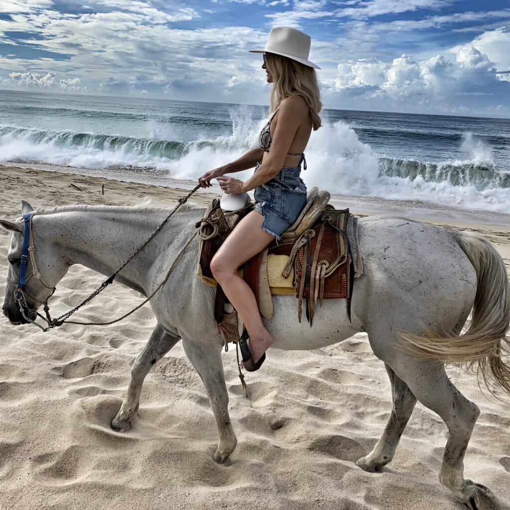 Dallas blogger riding a horse on the beach
