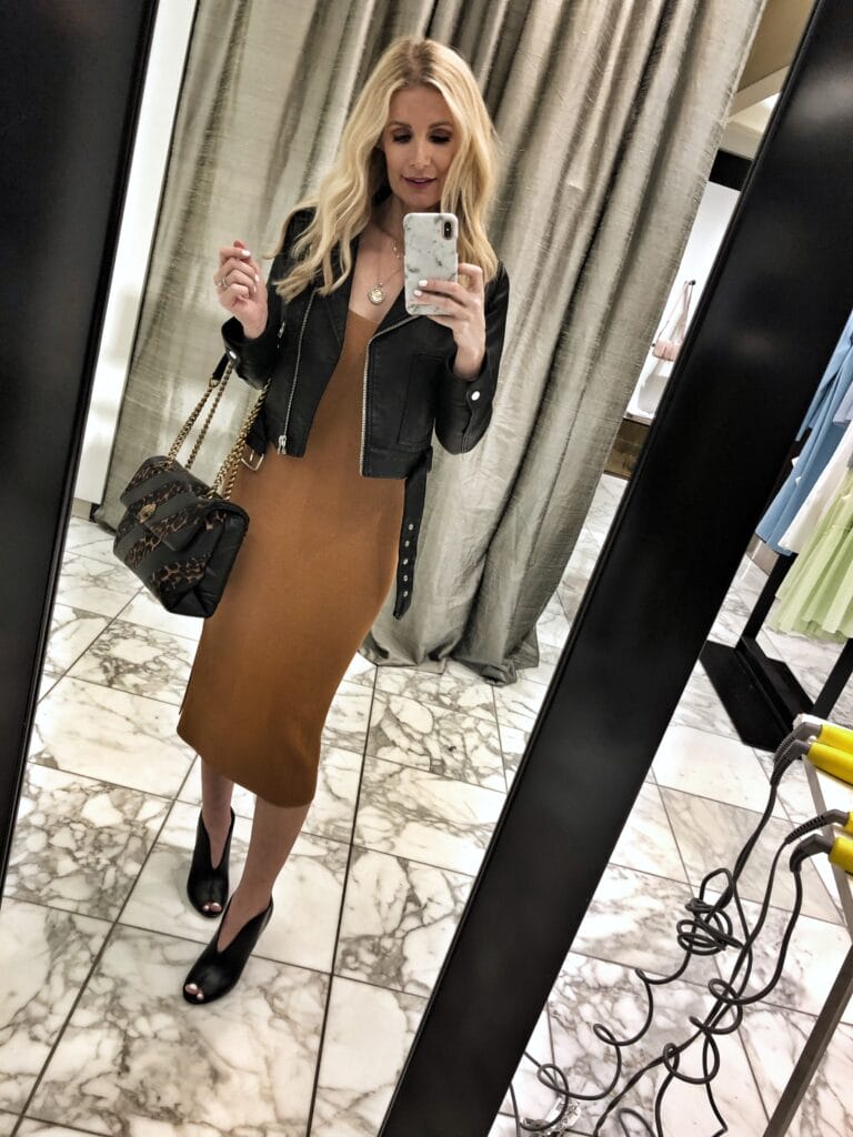 Dallas influencer wearing a midi dress and black moto jacket