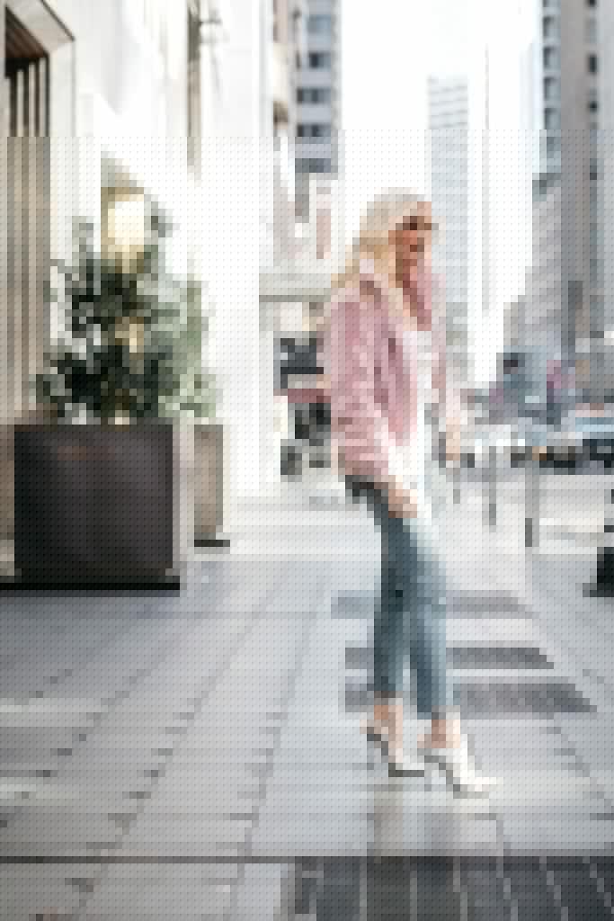 Style blogger wearing a blush colored jacket with denim and heels
