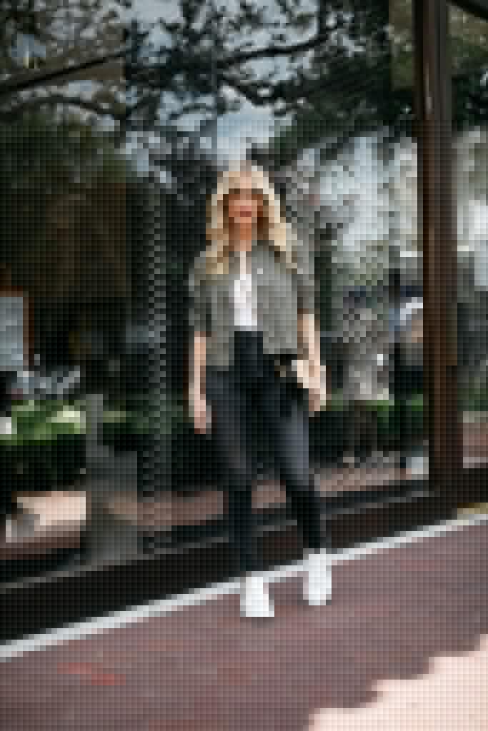 Style blogger wearing a white tank and utility jacket with black jeans