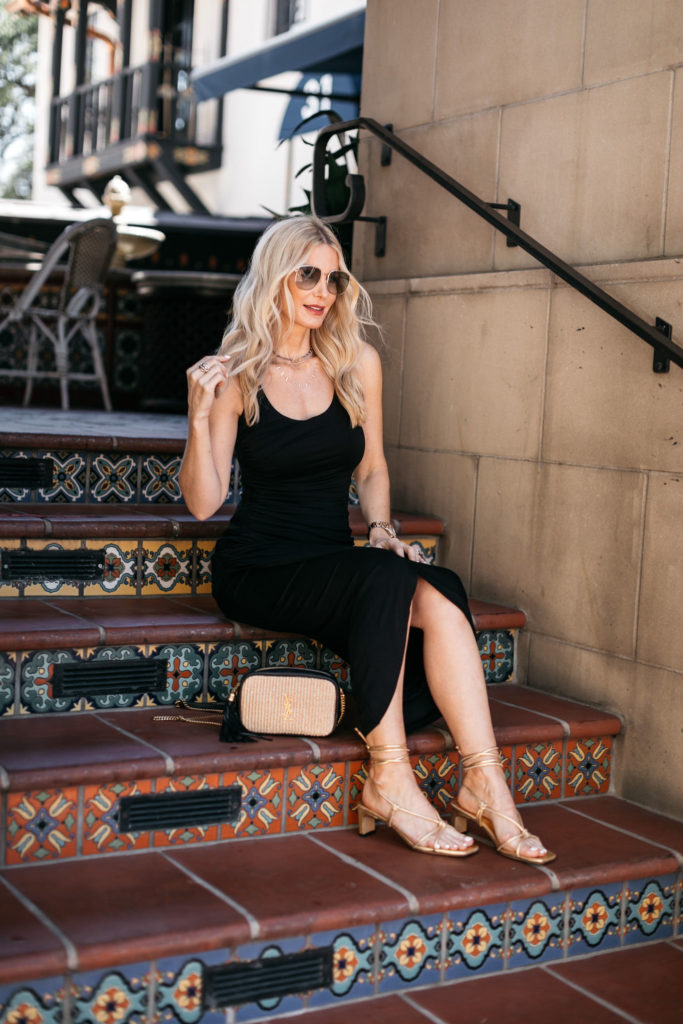 Dallas fashion blogger wearing a black dress and gold sandals