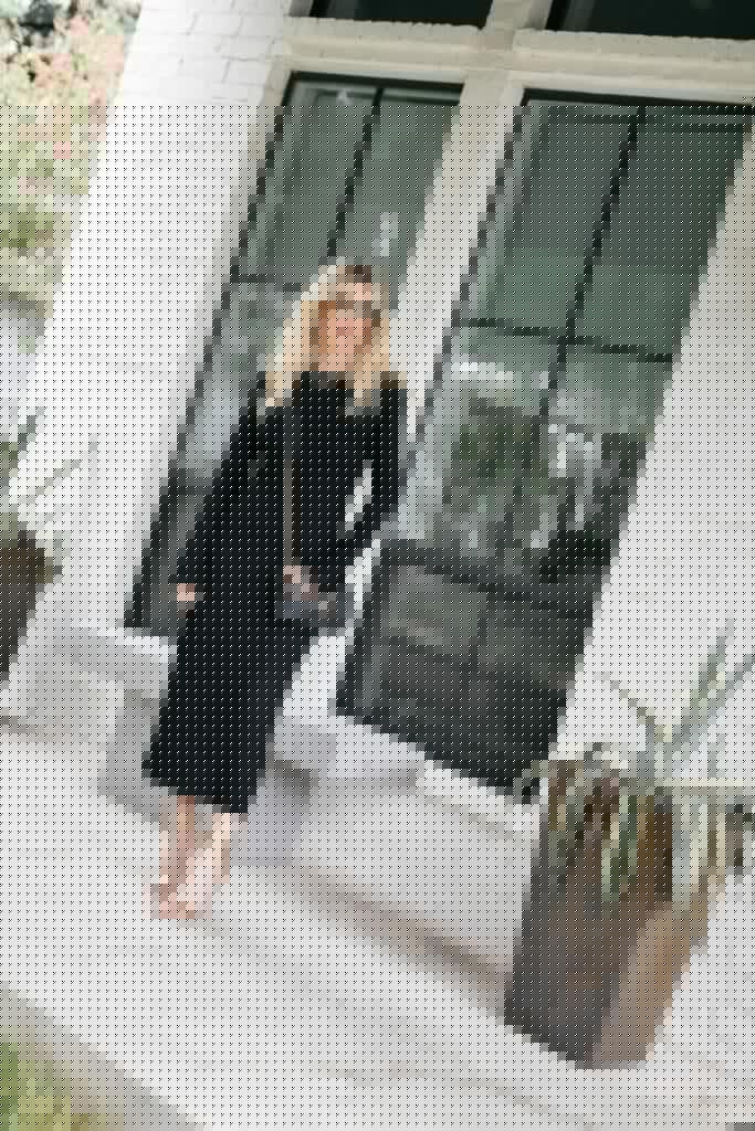 Fashion blogger wearing a long-sleeve black dress and gold heels for fall and winter