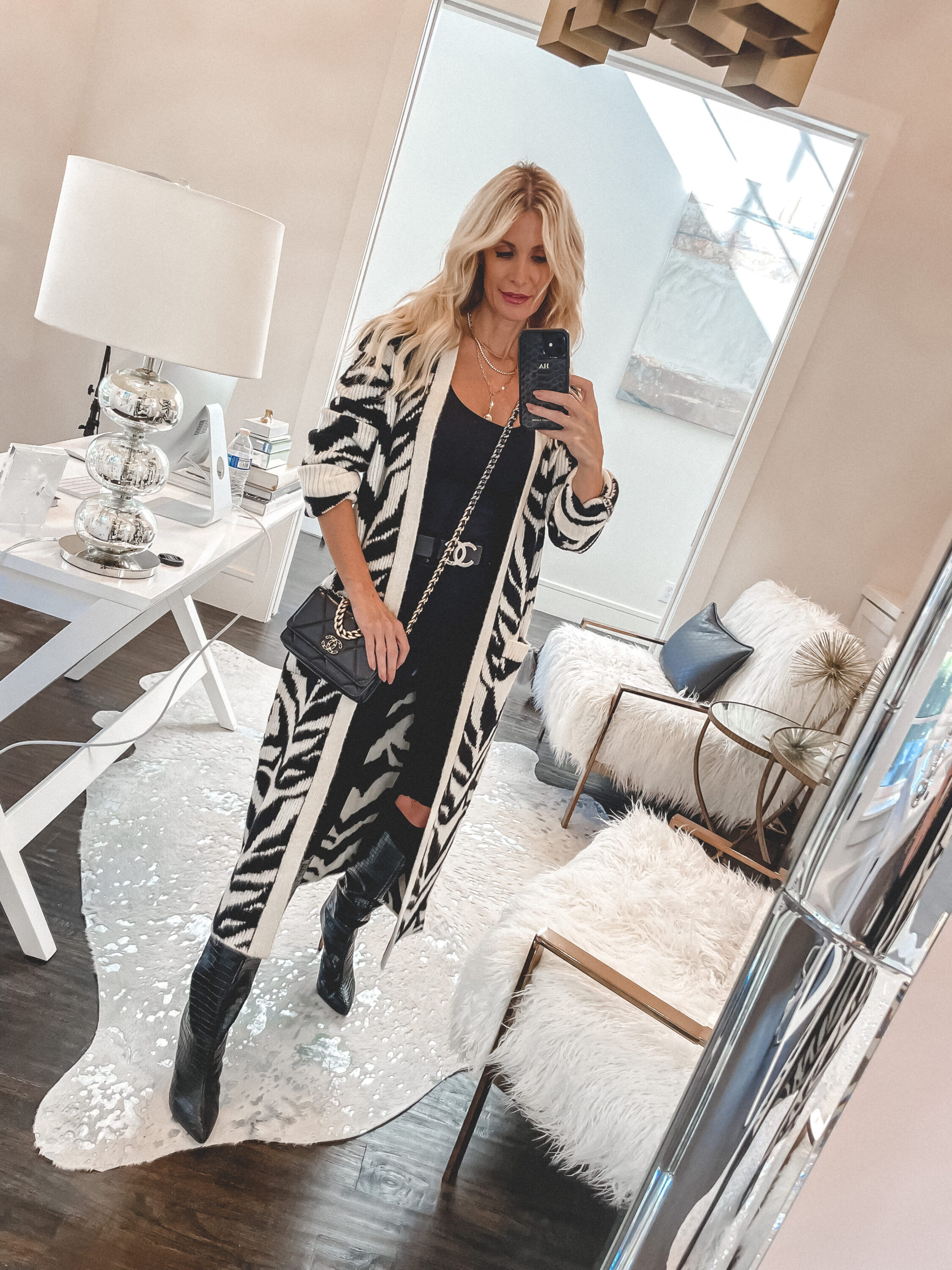 So Heather blog wearing a white and black zebra print cardigan and leather knee high boots