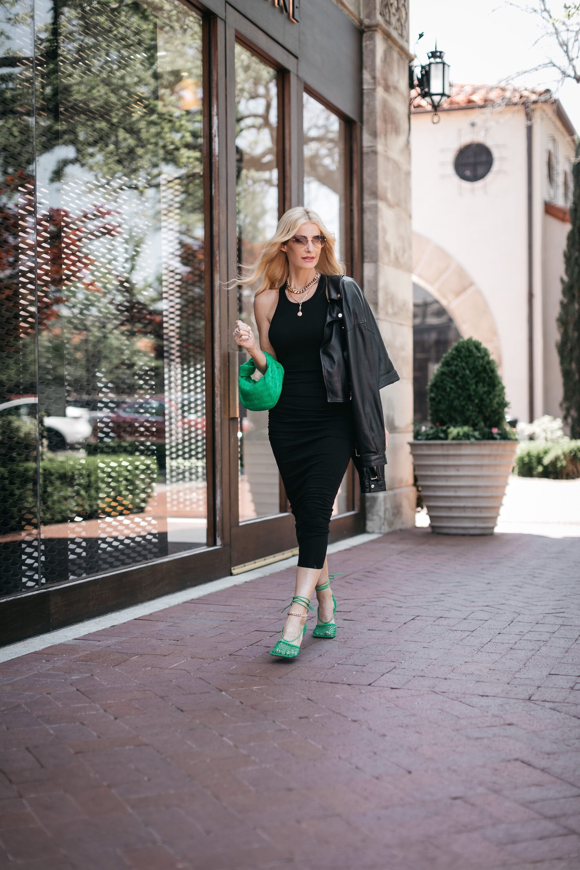 Woman over 40 wearing racerback tank dress with trending green accessories 