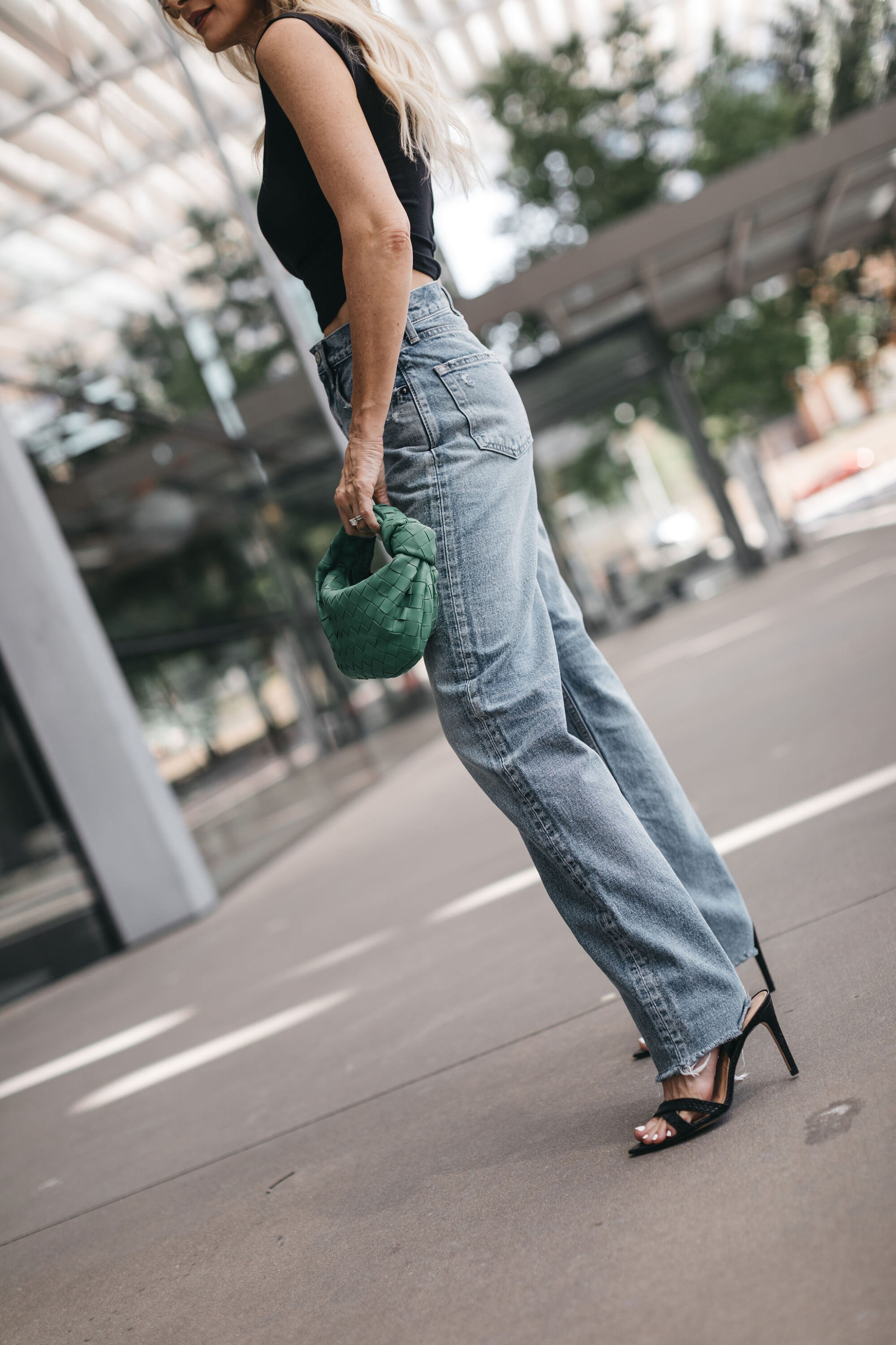woman over 40 wearing black corset top with baggy denim on trend for fall 2022