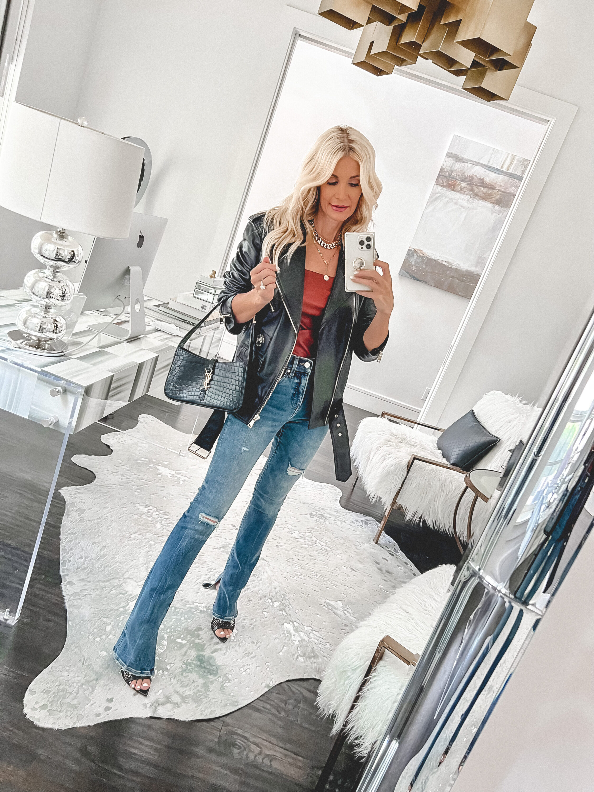 Dallas woman over 40 wearing black leather jacket with fitted flare jeans and red top