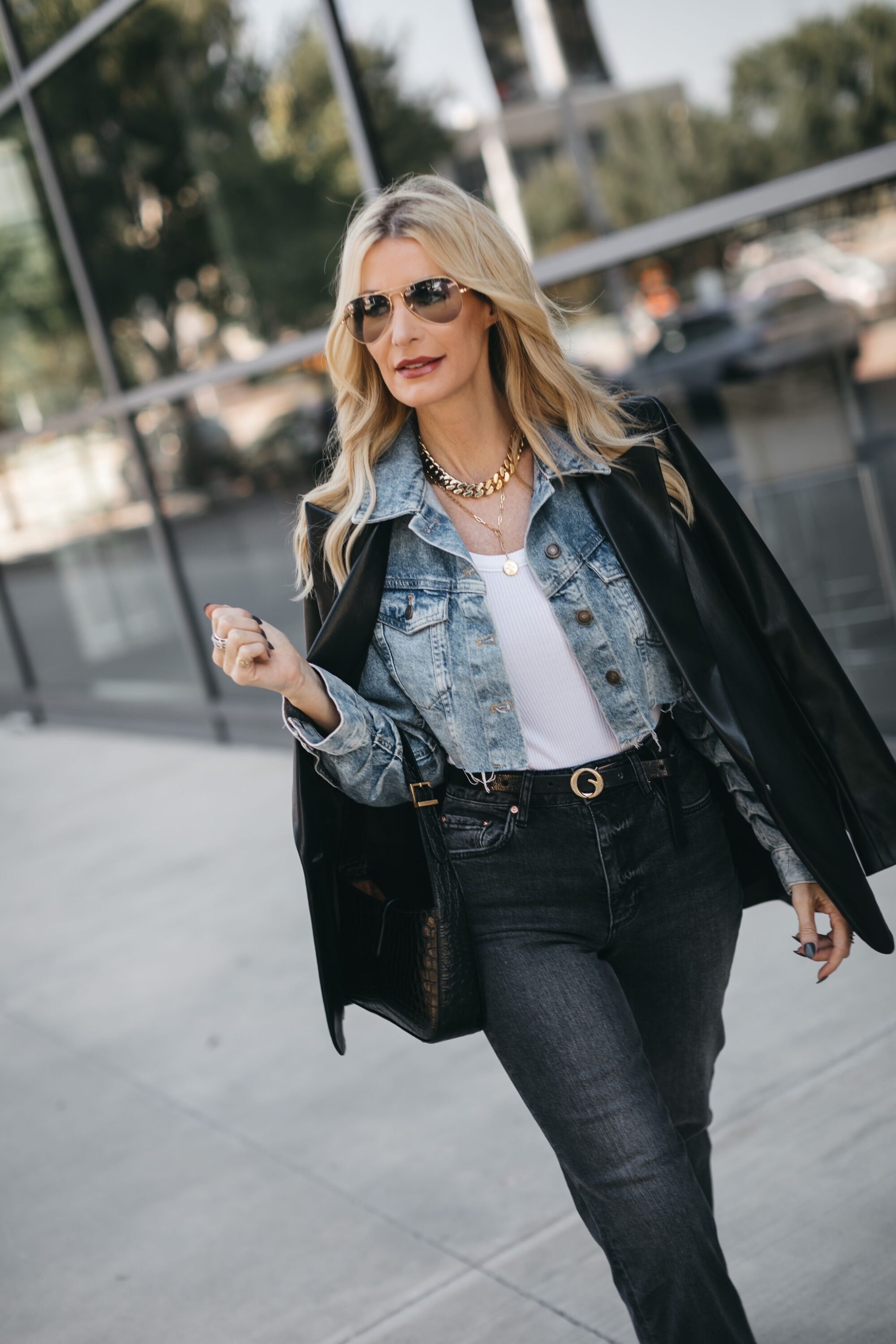 Woman over 40 wearing black/blue denim with white AGOLDE tank as base layer.