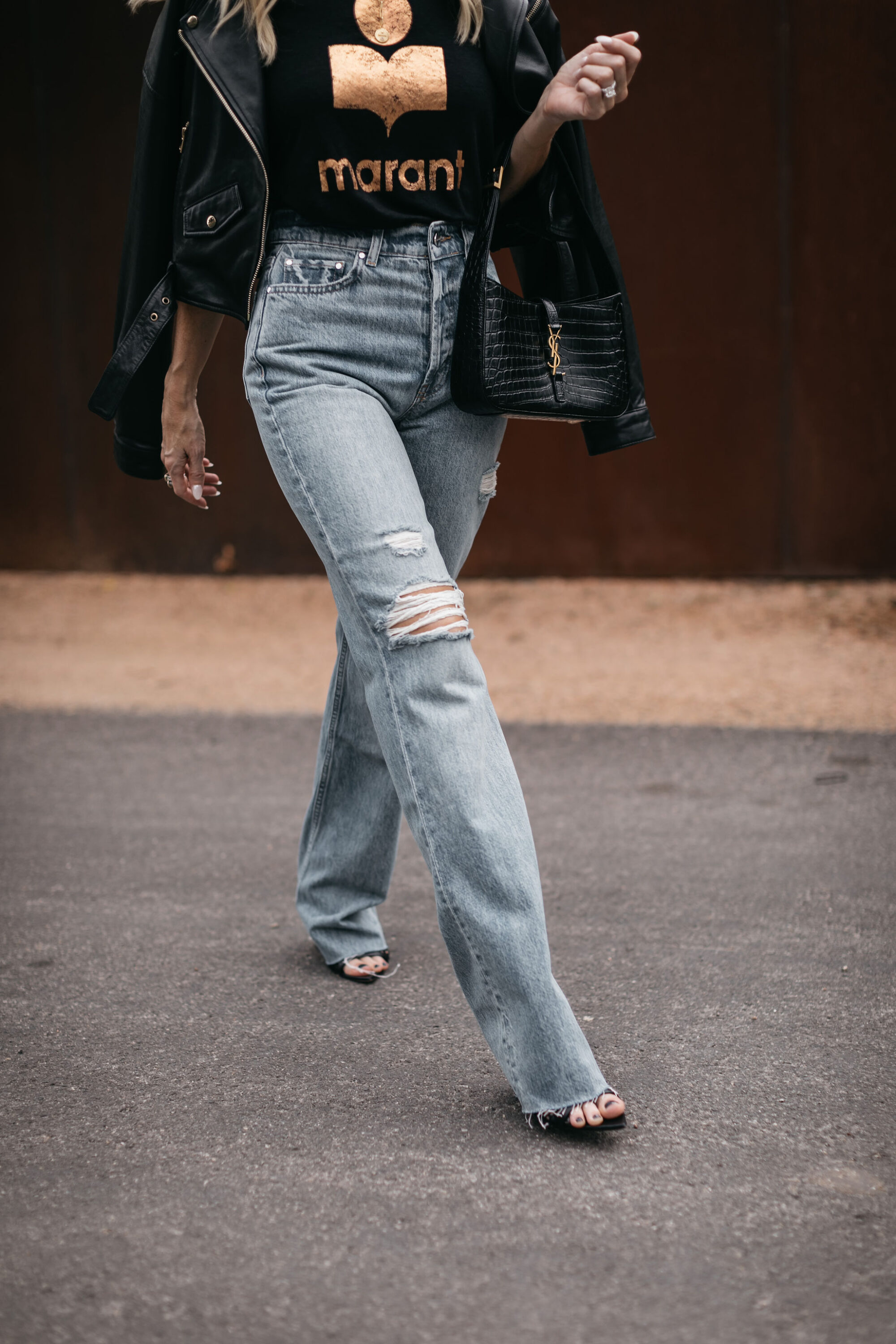 woman over 40 wearing Anine Bing jeans with black heels and leather jacket with graphic tee.