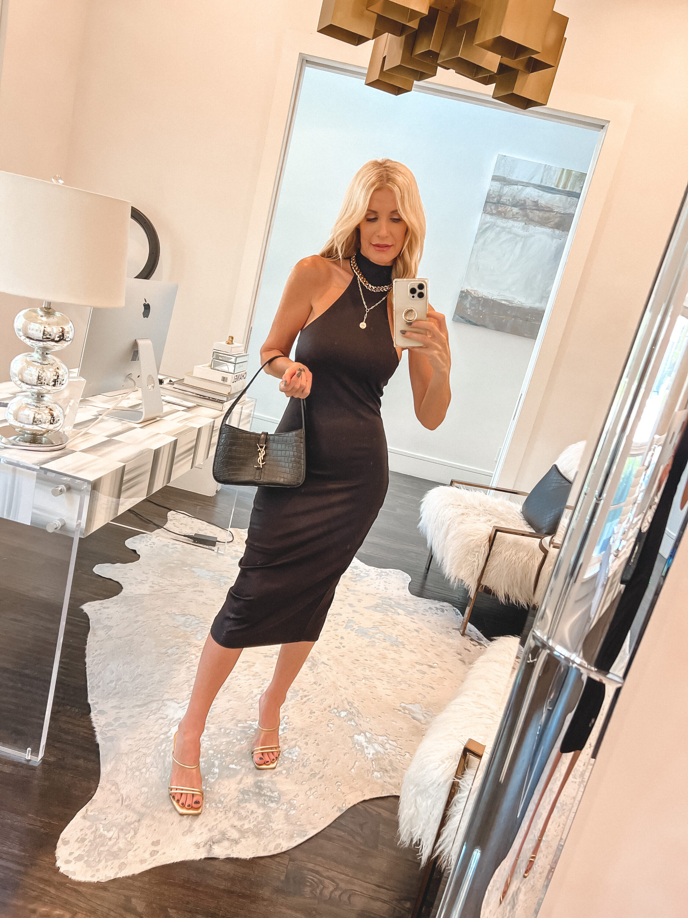 over 40 fashion influencer wearing high-neck black dress as an affordable fall look.