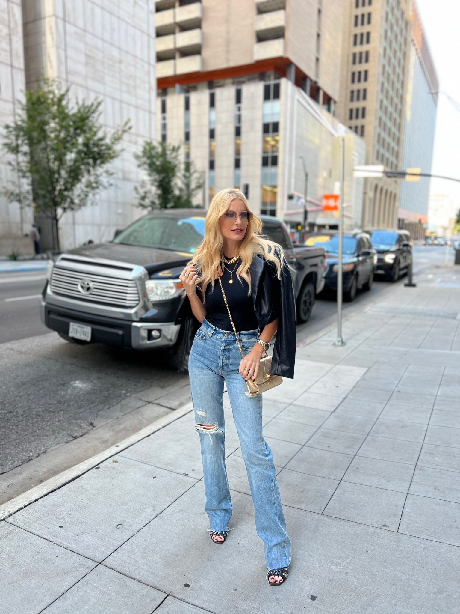 Dallas fashion blogger over 40 wearing baggy denim with a black tank and cropped leather blazer.