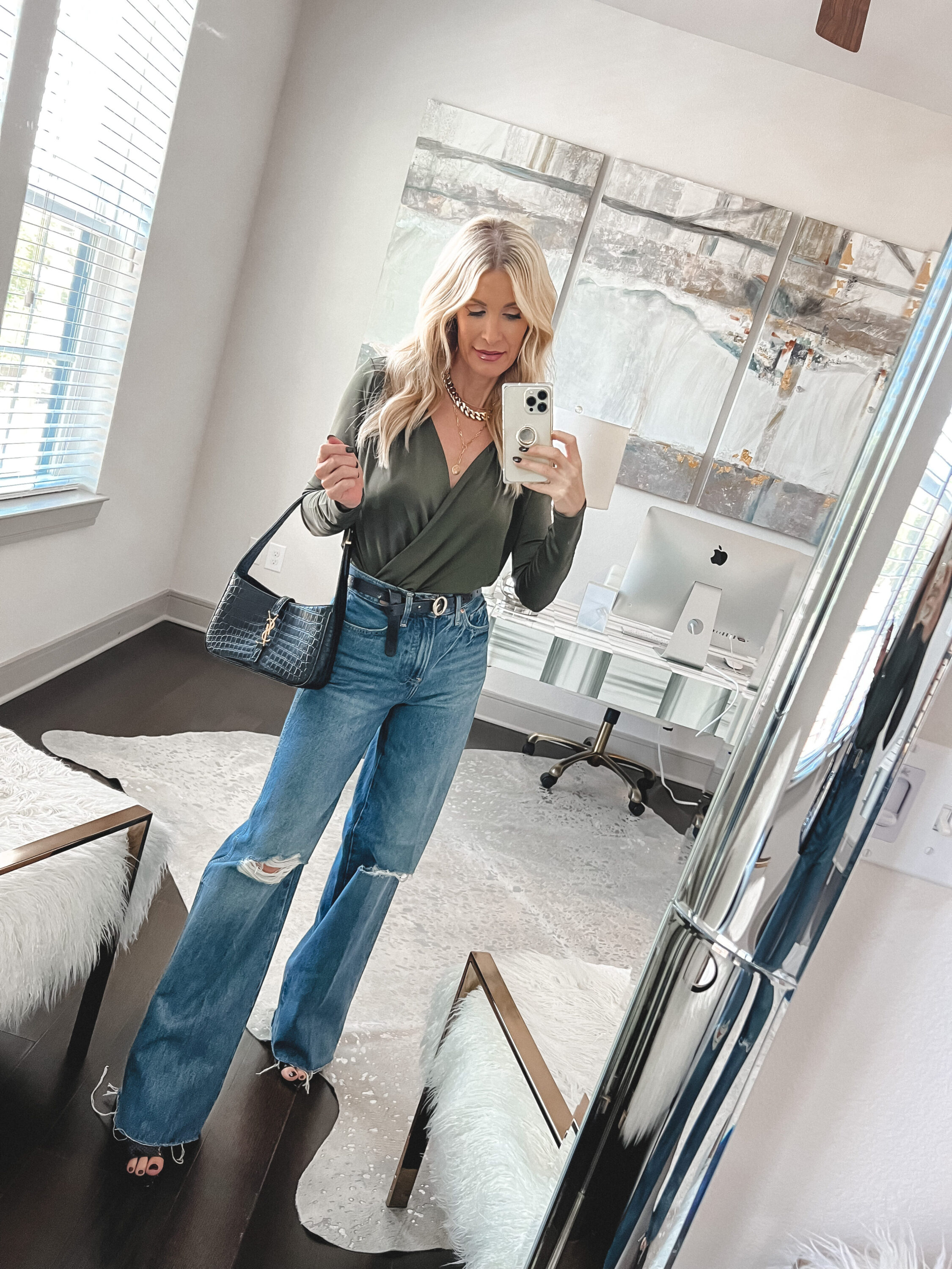 Over 40 fashion influencer wearing a chic wrap style bodysuit with wide leg jeans.