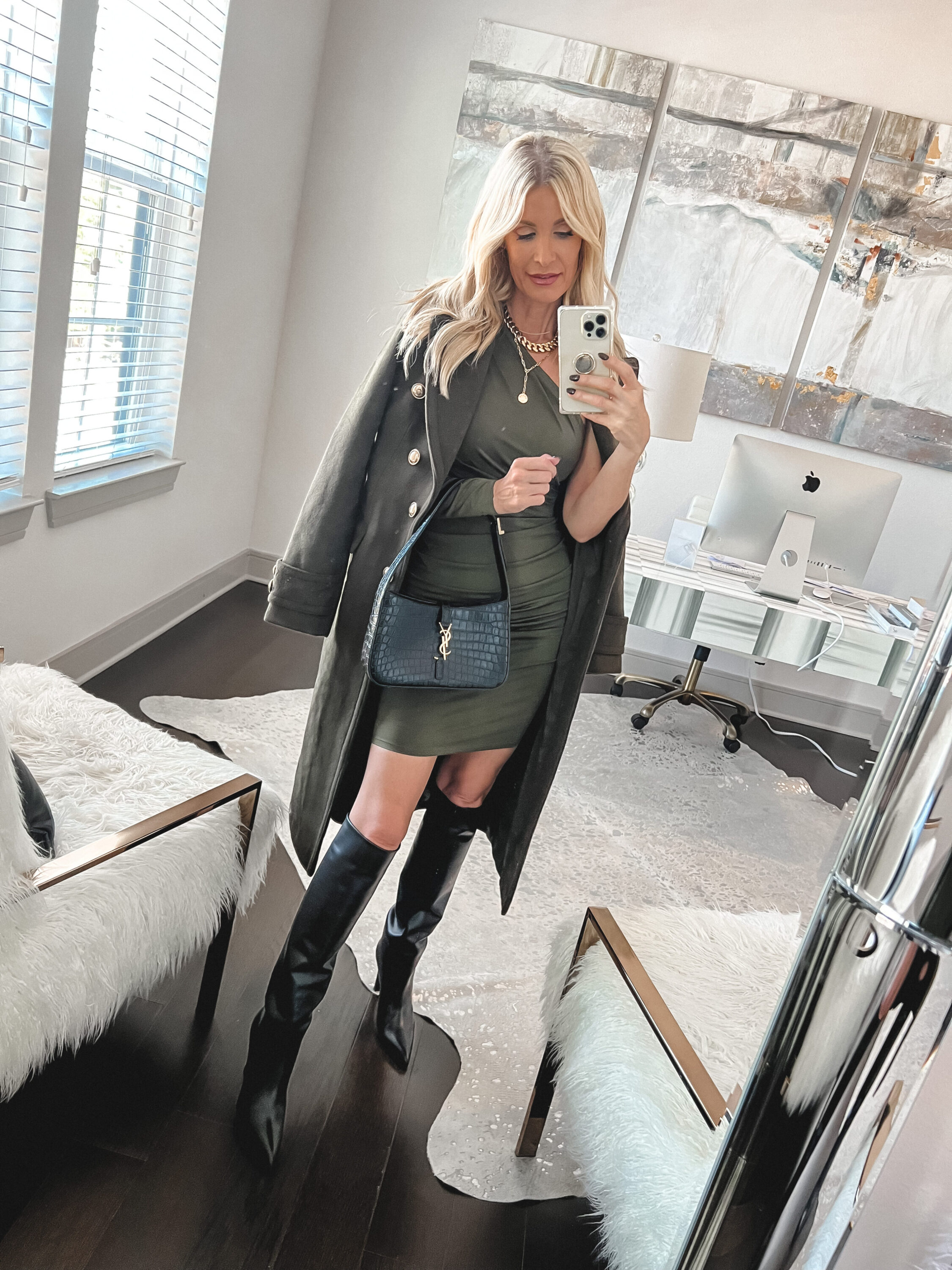 Over 40 fashion influencer wearing wool blend trench coat with green body con dress and croc-embossed boots.