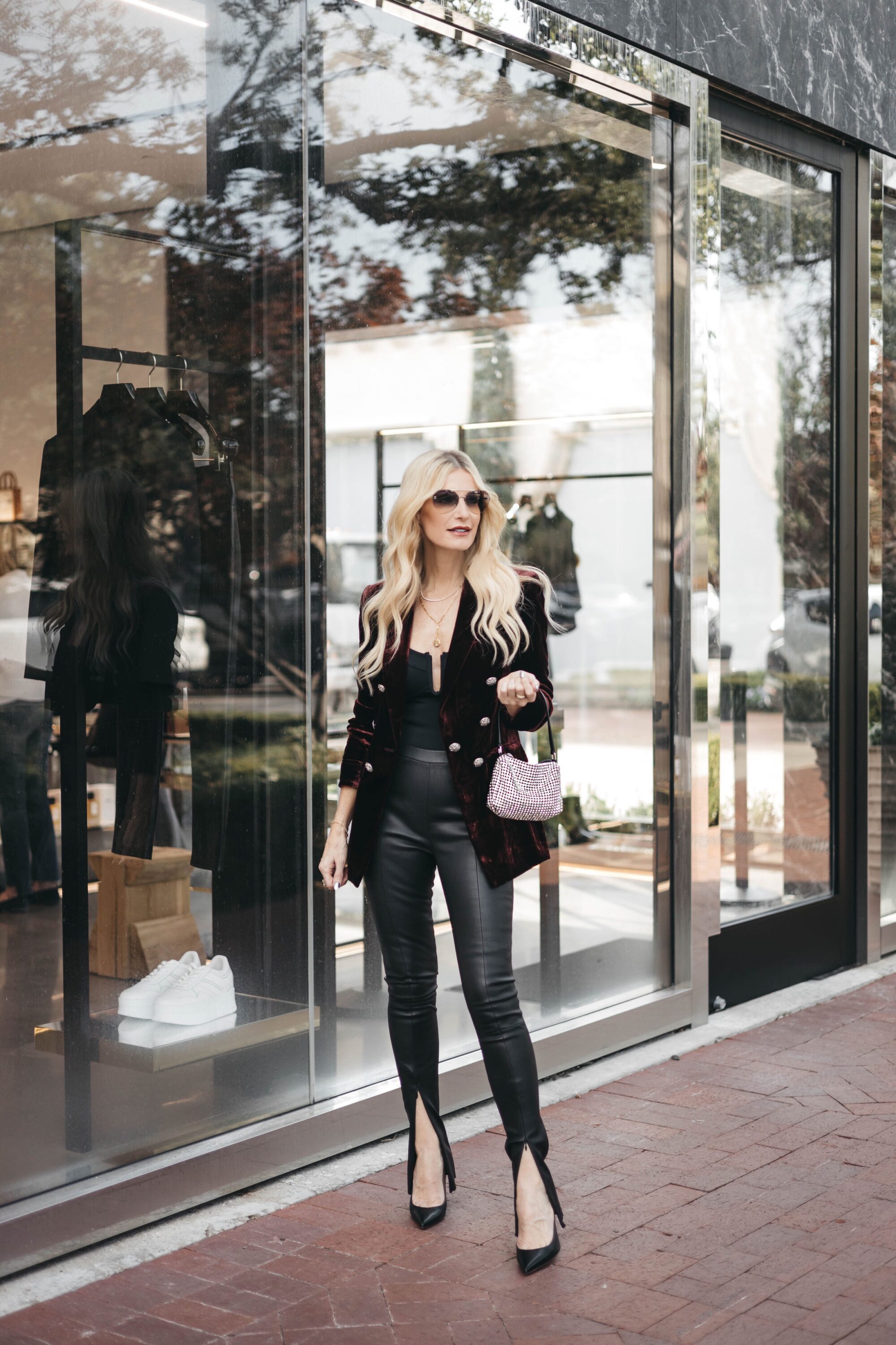 Dallas woman over 40 wearing leather split hem pants with velvet blazer.