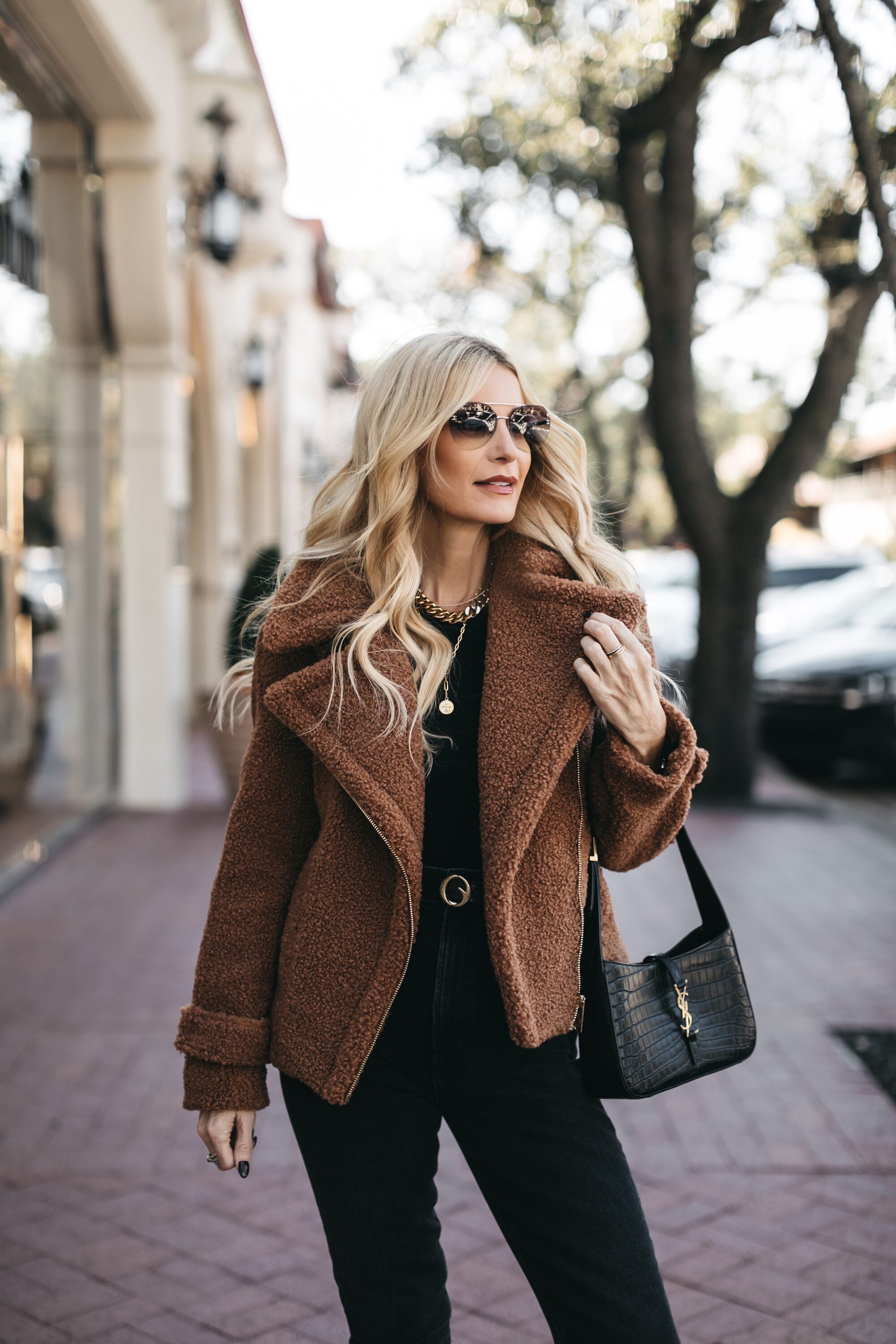 Over 40 fashion blogger wearing faux fur coat and modern skinny jeans with knee high boots.
