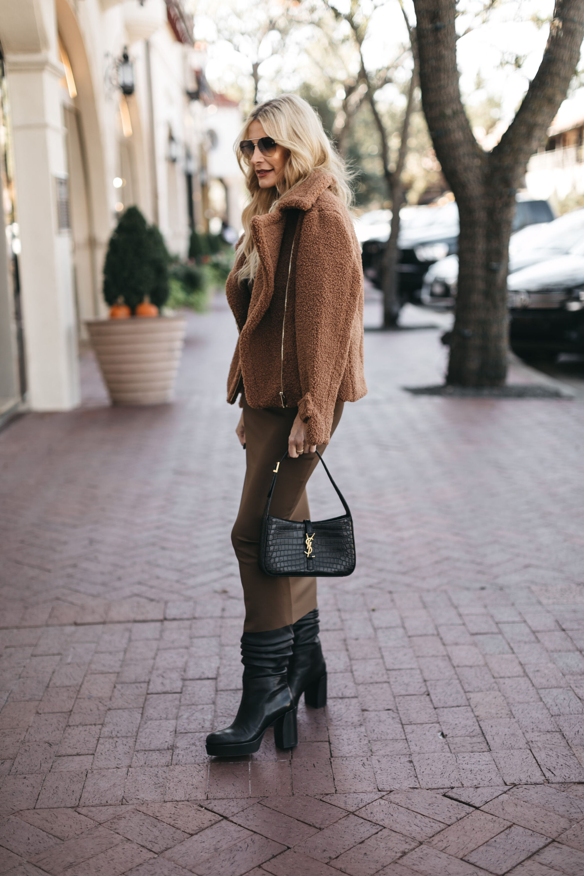 Dallas fashion influencer over 40 wearing faux fur bomber jacket with brown midi dress and black platform boots.