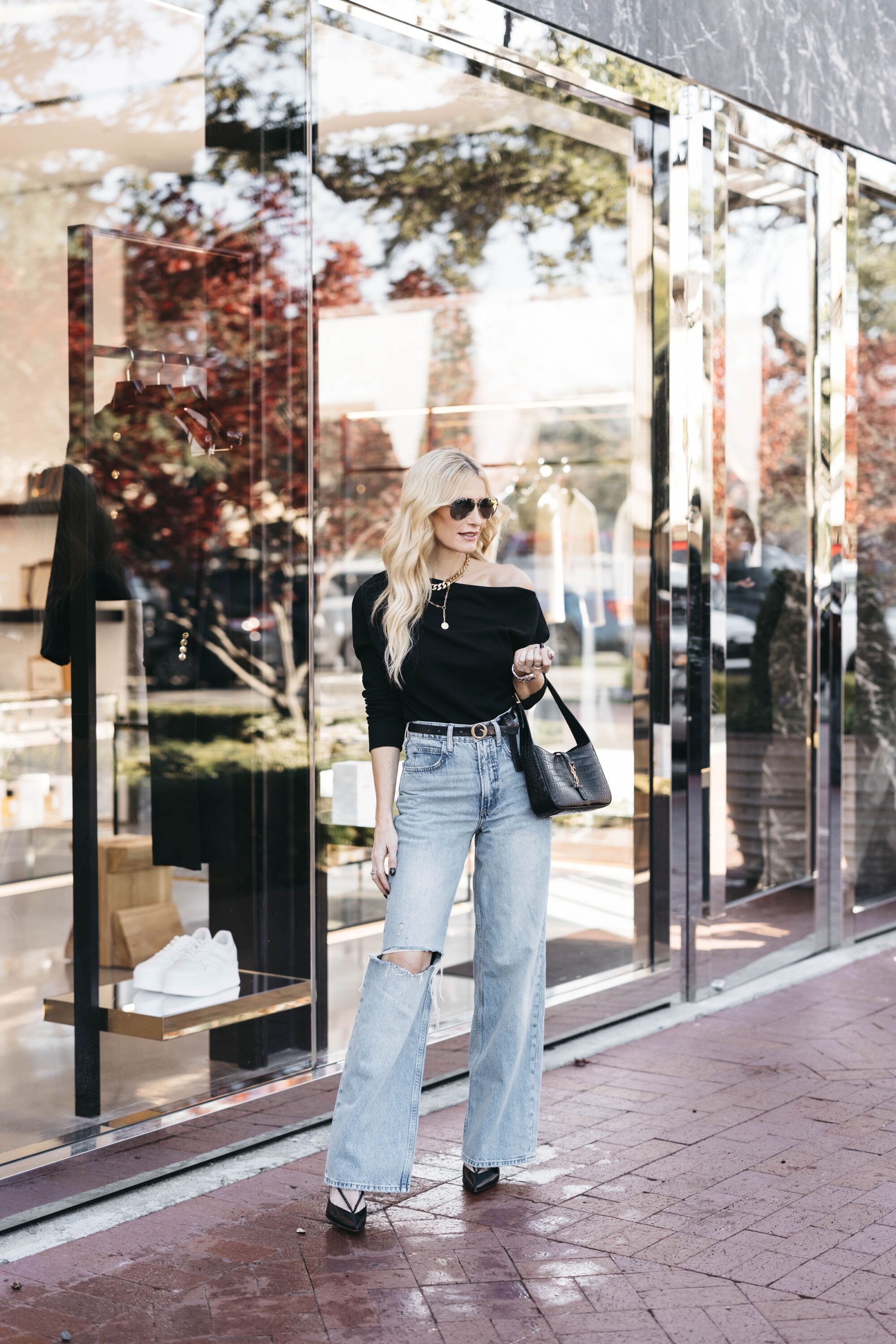 Over 40 dallas influencer wearing baggy denim with a black off the shoulder top as how to style baggy jeans.