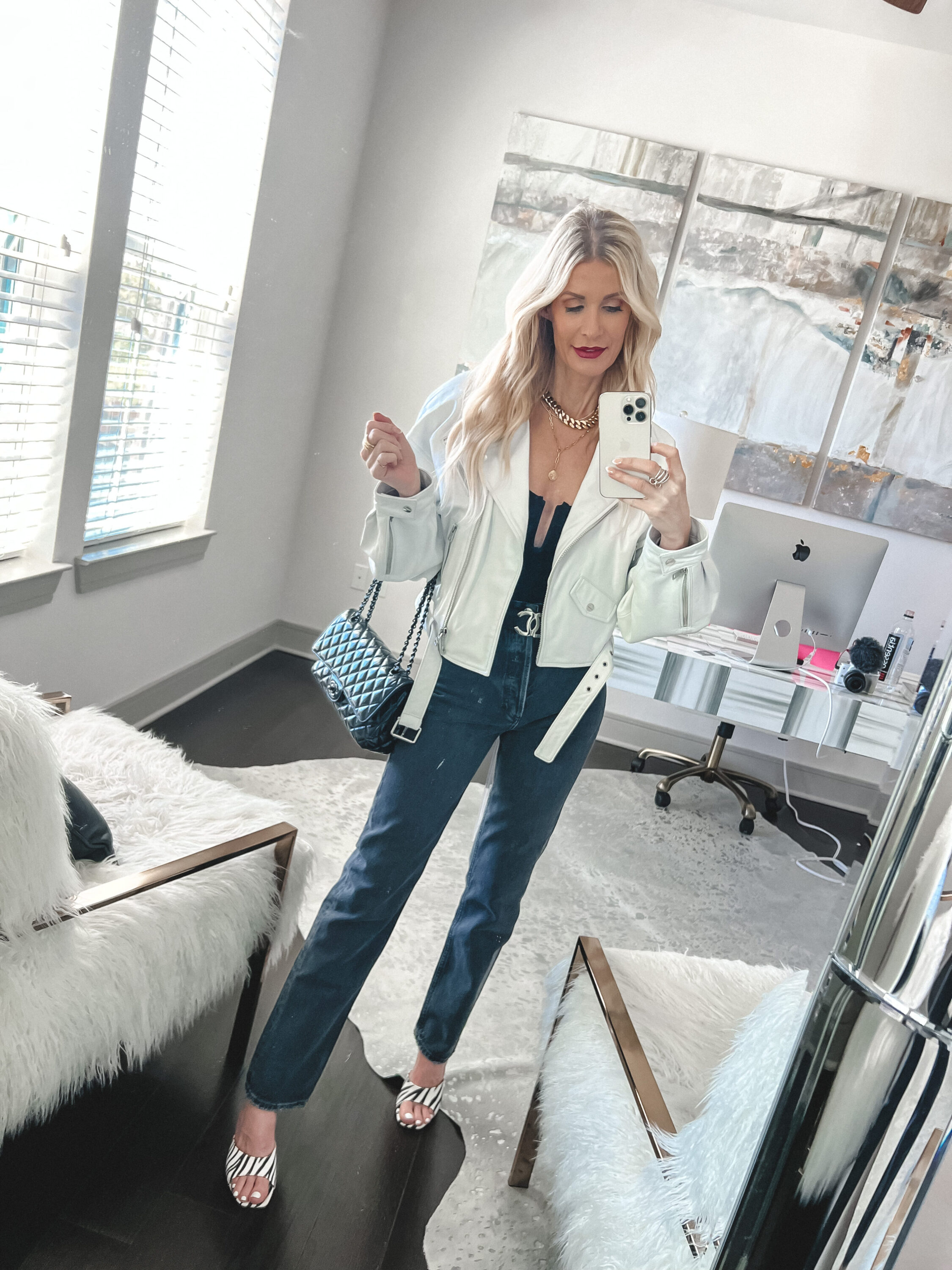 Over 40 fashion influencer wearing all black with a white jacket over top as one of 5 easy outfit formulas.