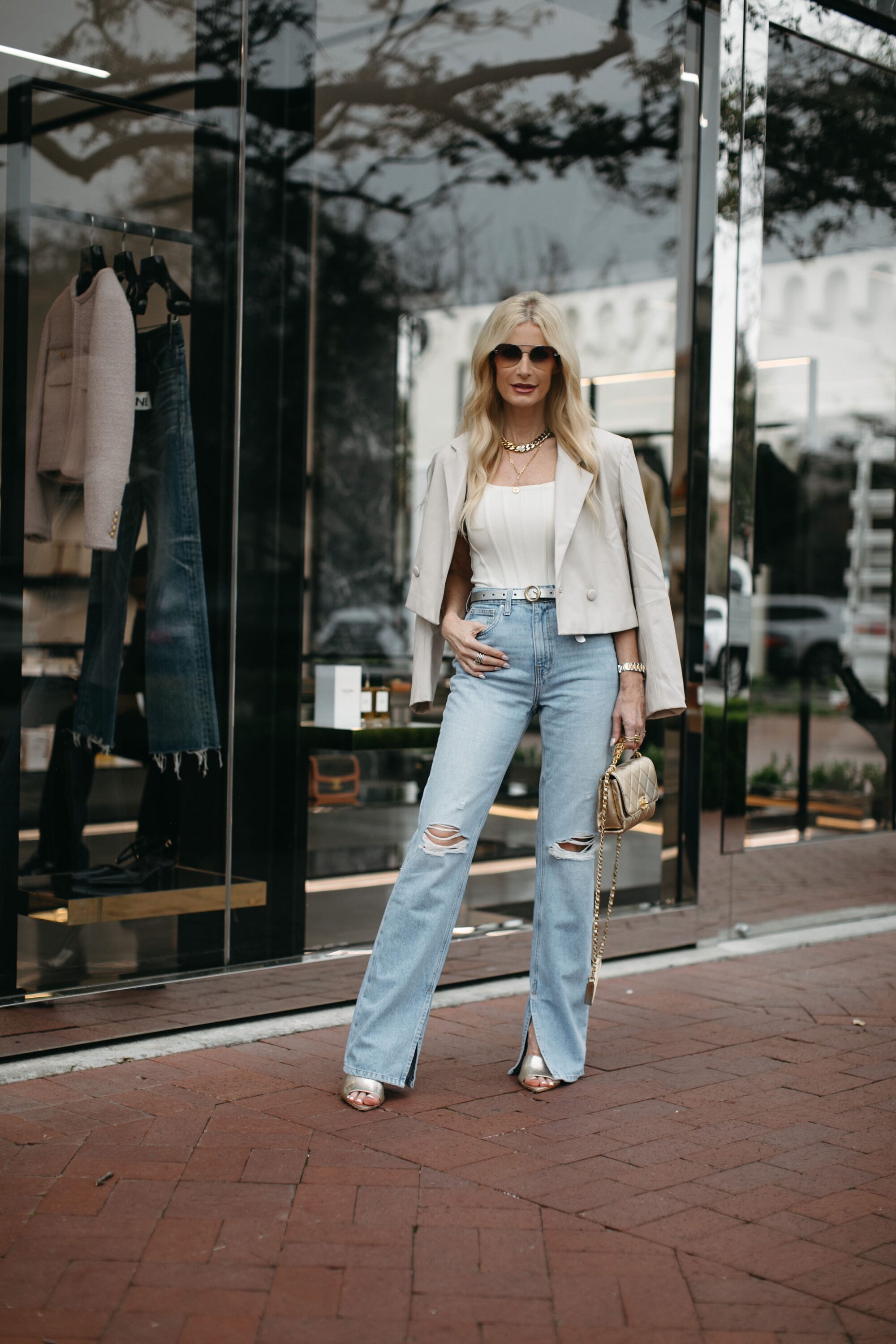 Dallas woman over 40 wearing ivory leather jacket over white corset top with high-waisted distressed jeans.
