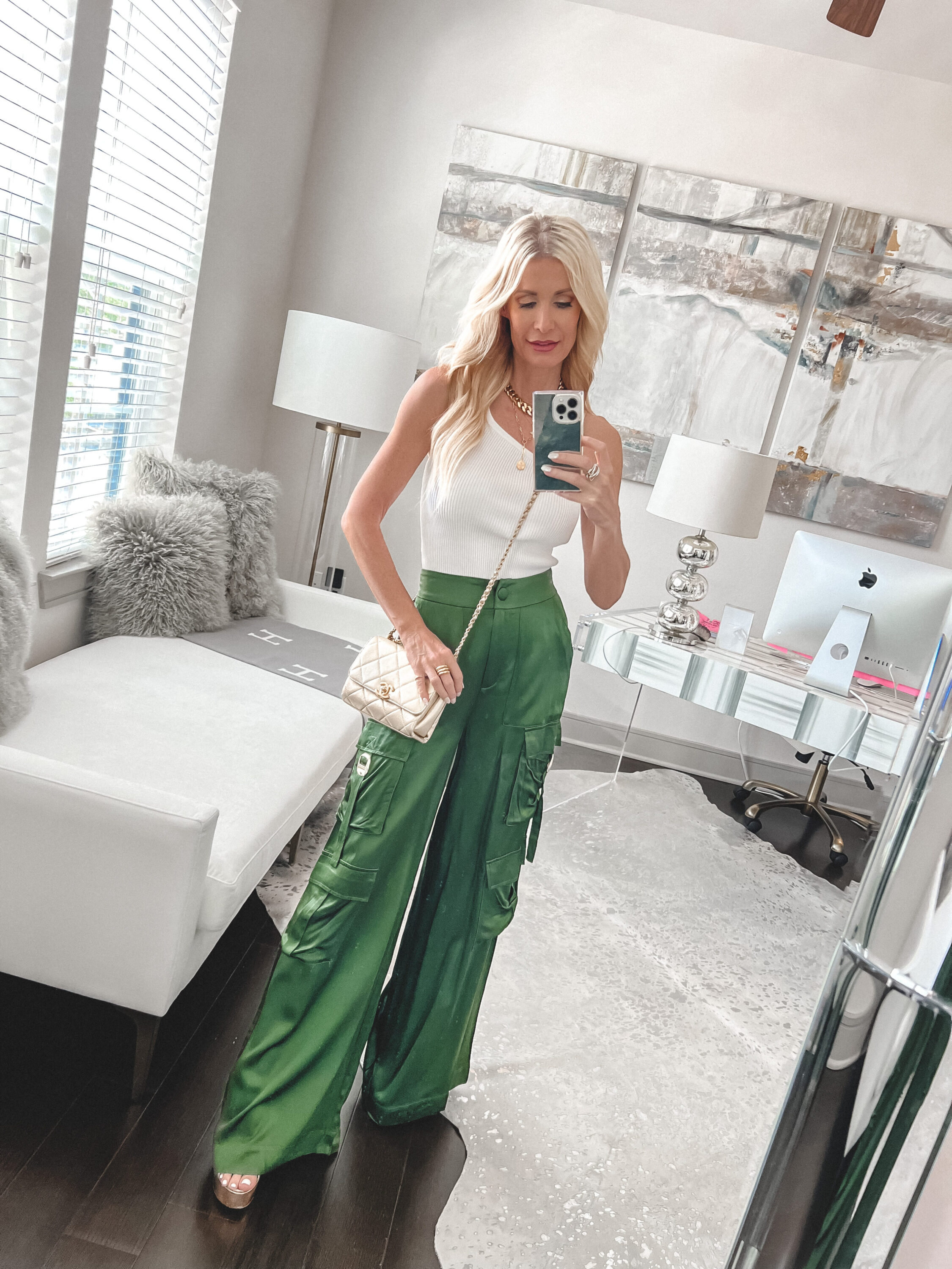 Dallas woman over 40 wearing olive satin cargo pants with a white one shoulder top.