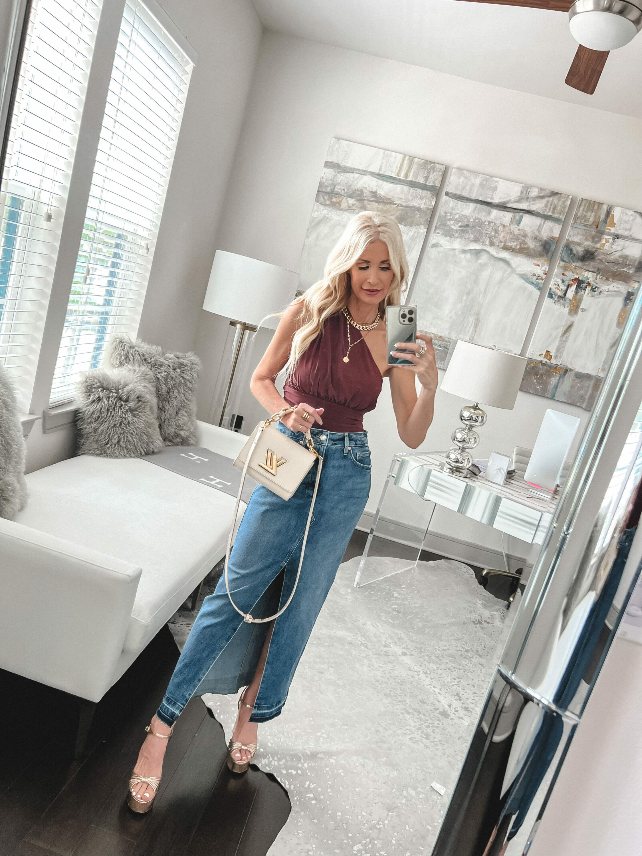 Dallas fashion icon wearing red one-shoulder top with denim midi skirt and gold platforms.