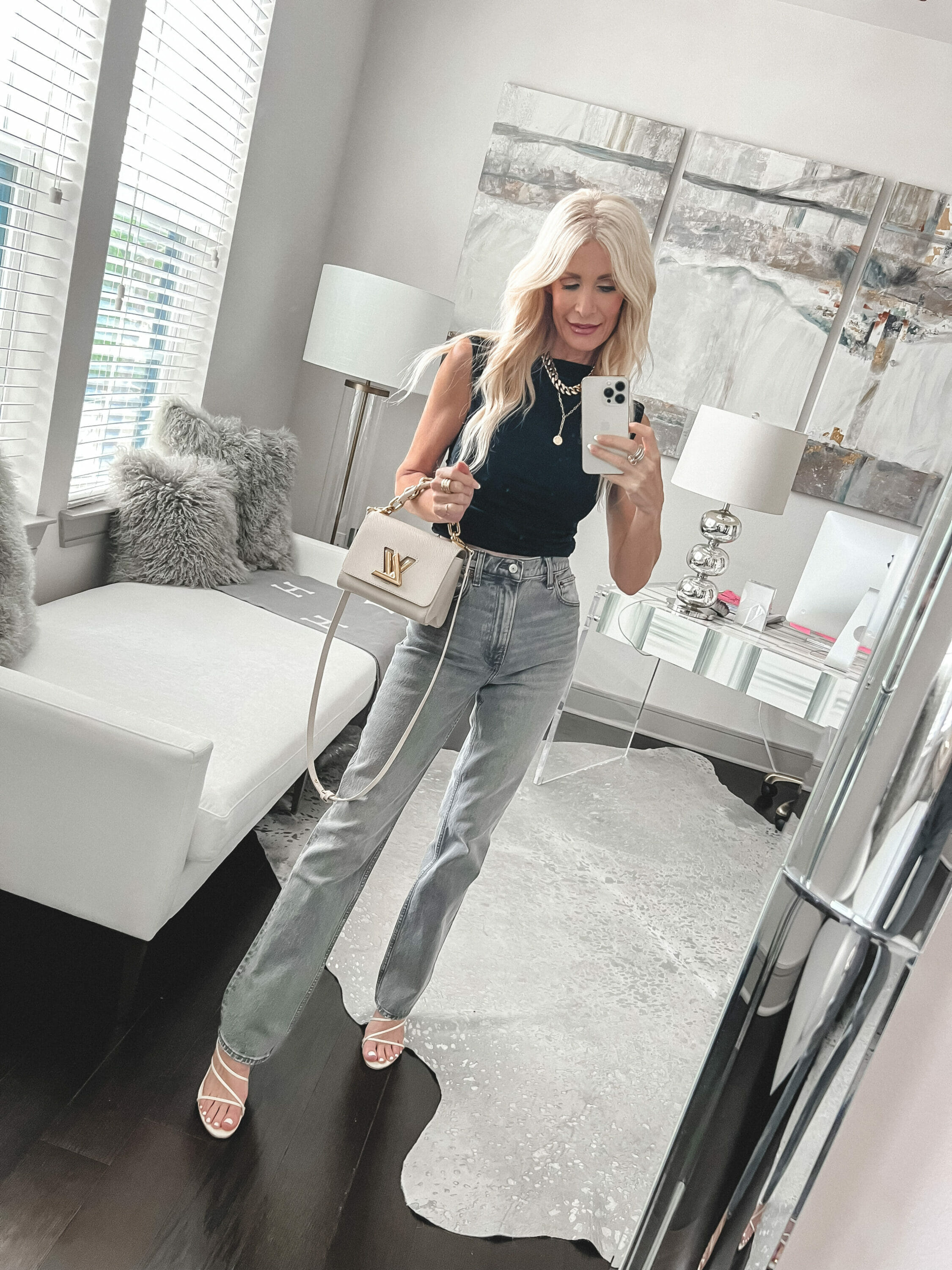 Over 40 fashion blogger wearing black shell top with grey jeans as one of the best tops for women over 40.