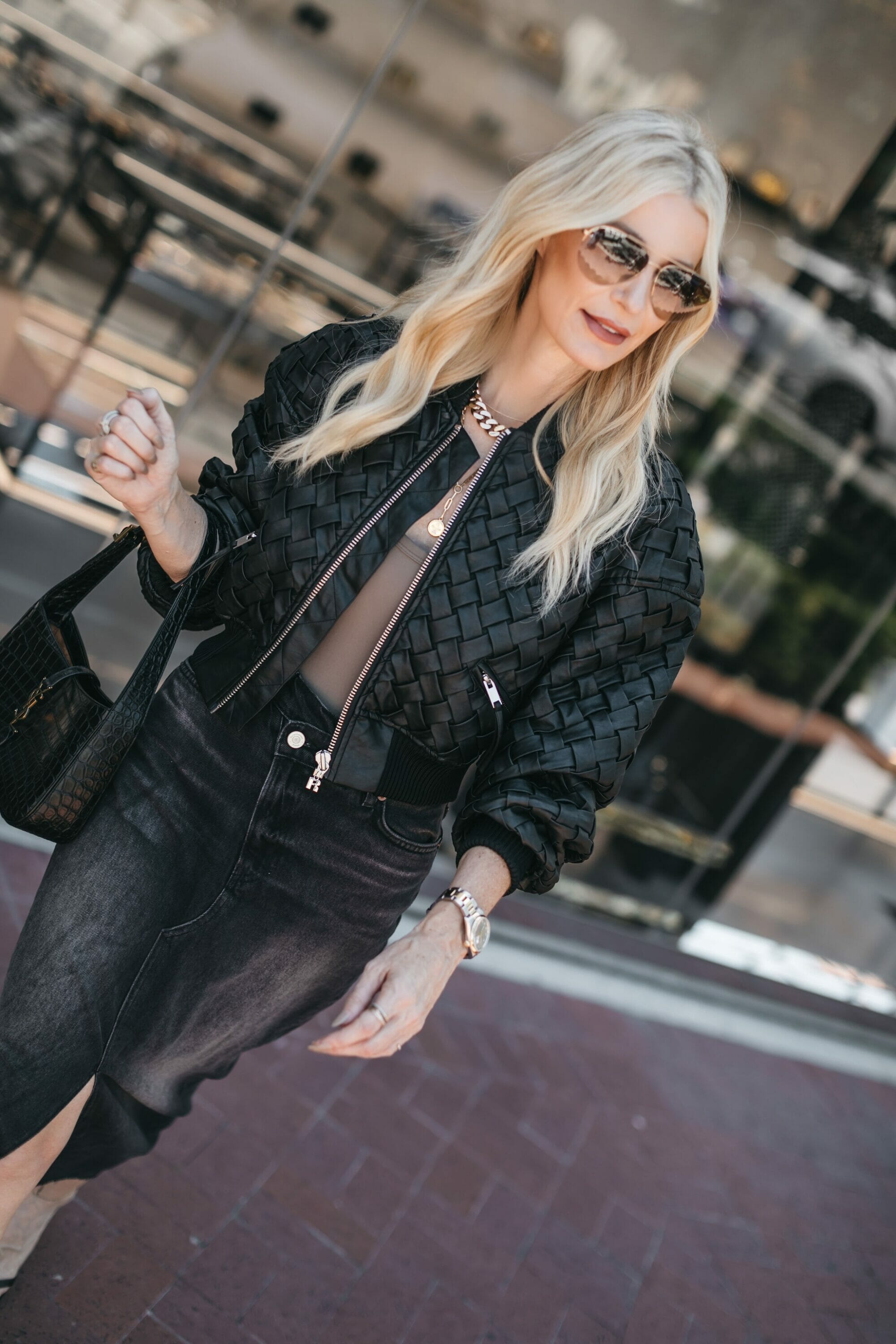 Dallas woman over 40 wearing black midi skirt with black quilted leather jacket.