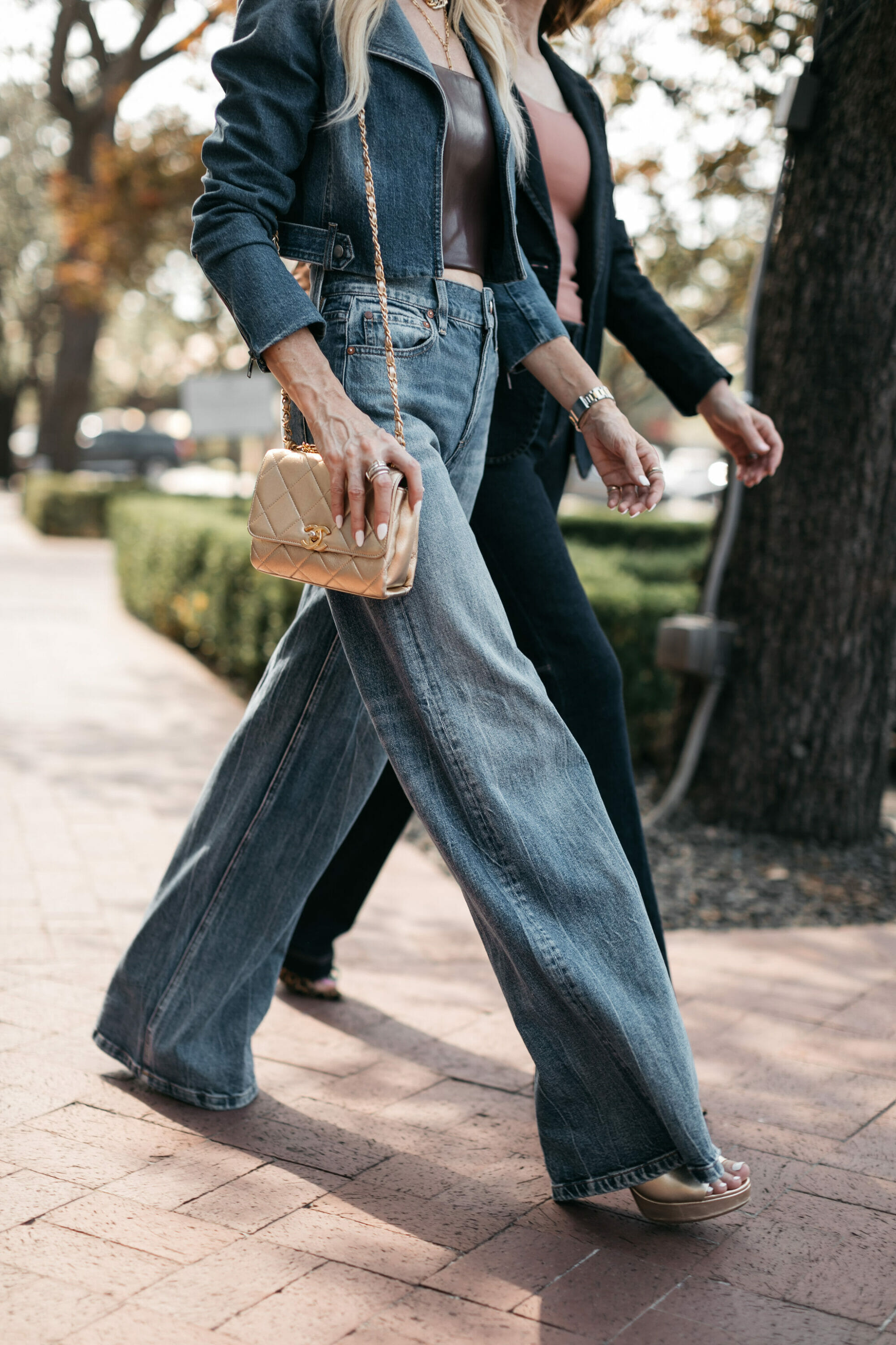 Over 40 stylists wearing wide leg jeans with gold accesories.