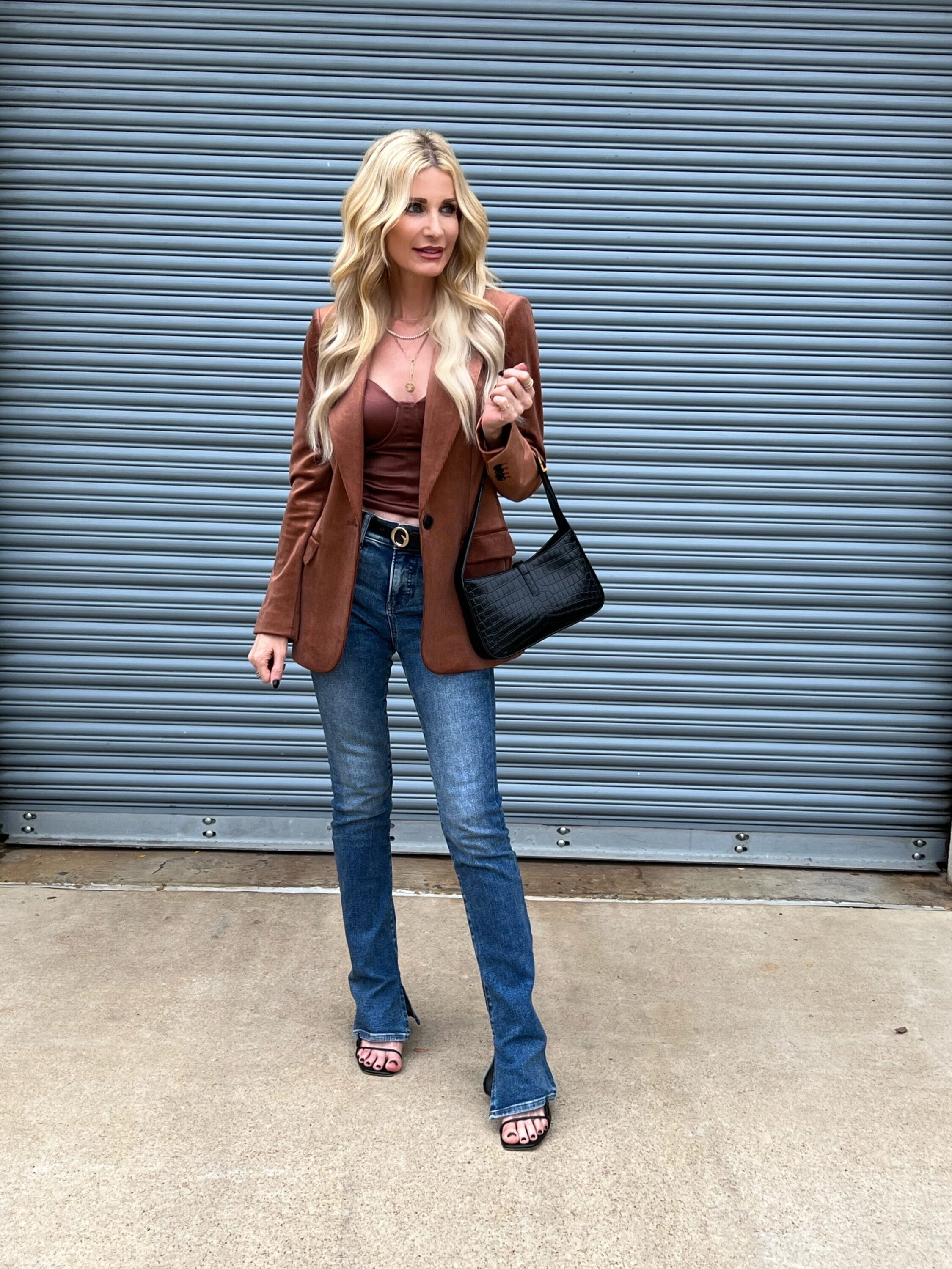 Dallas fashion influencer for women over 40 wearing skyscraper jeans with a satin bustier top and corduroy blazer as one of the hottest denim trends of 2024.