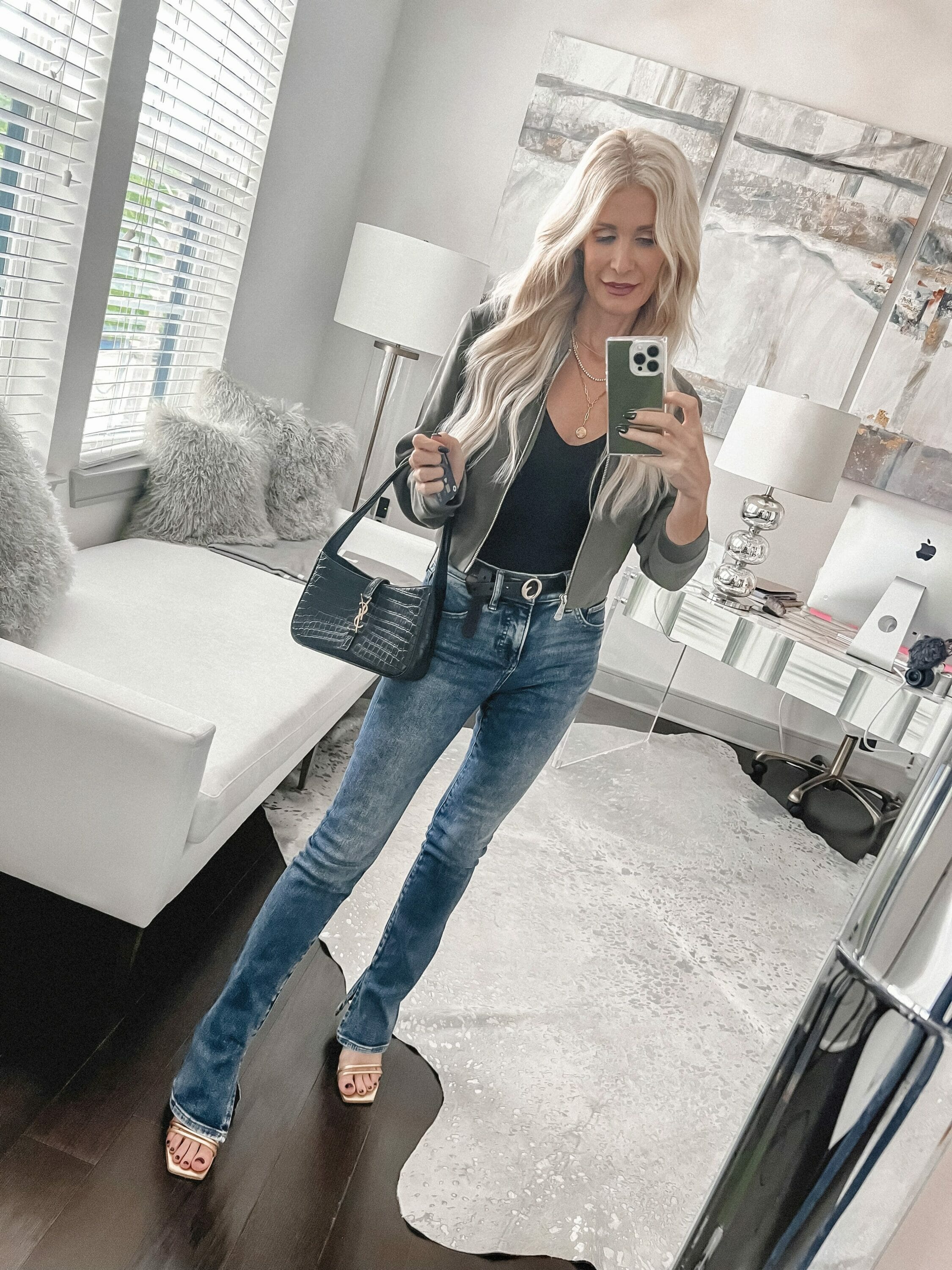 Dallas fashion stylist for women over 40 wearing green bomber jacket with affordable jeans.