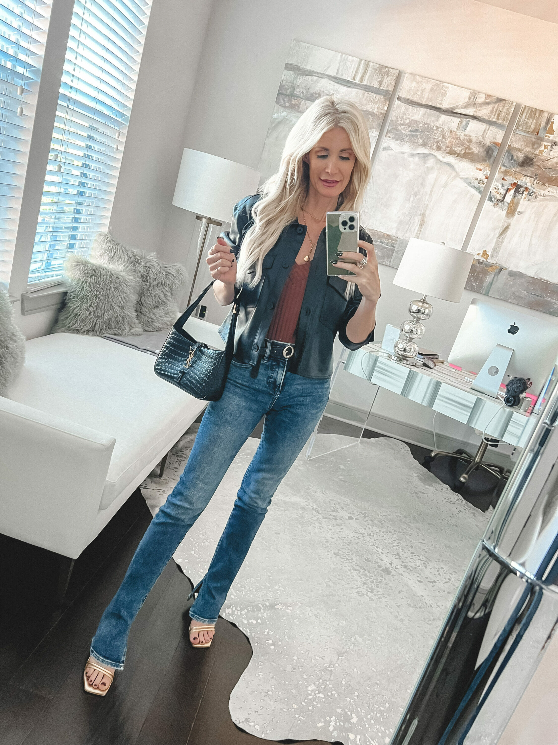 Dallas woman wearing under $100 skyscraper jeans with a faux leather shirt jacket and brown silk camisole.