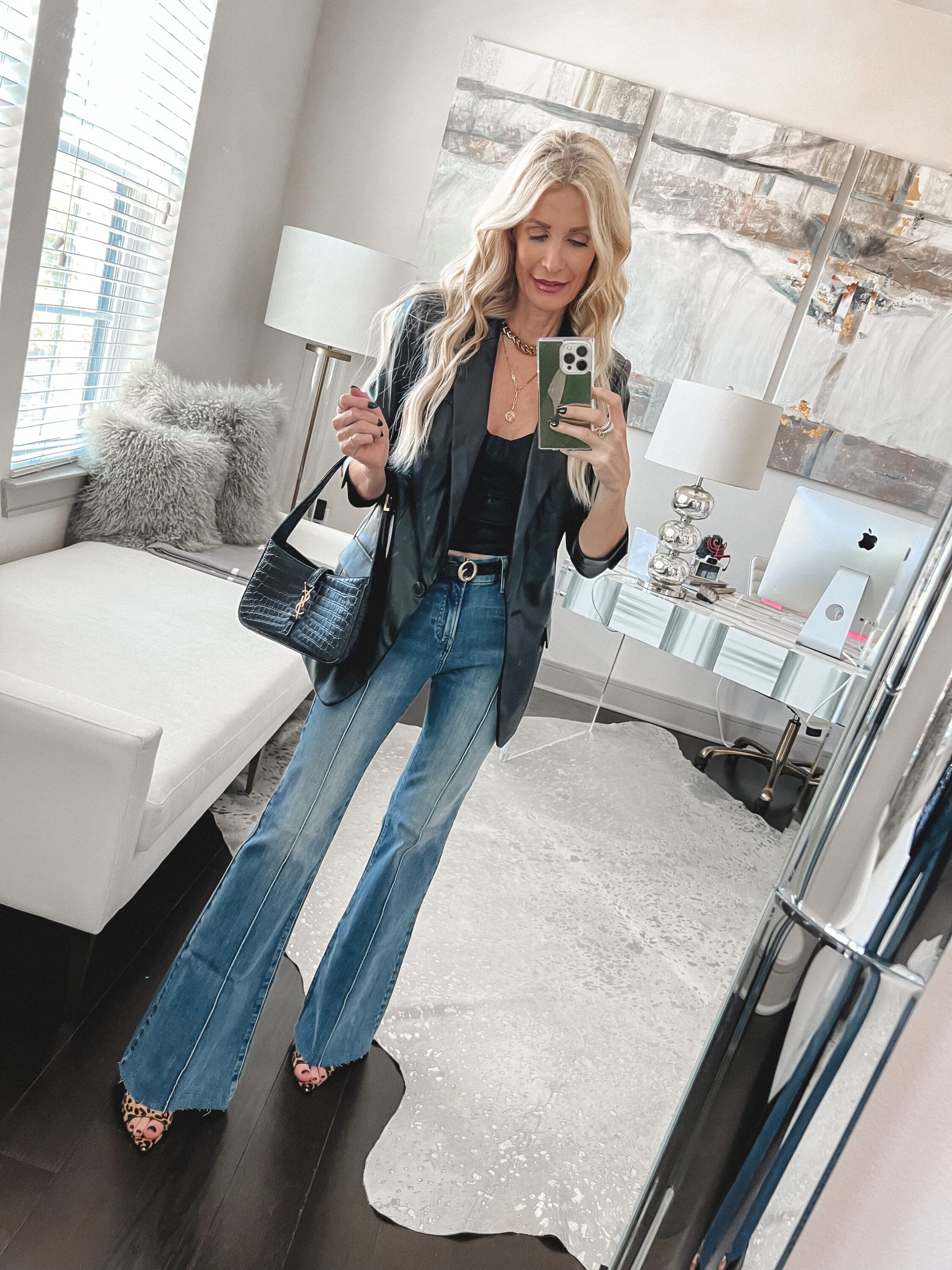 Dallas fashion stylist for women over 40 wearing a faux leathet blazer and 70's flare jeans.