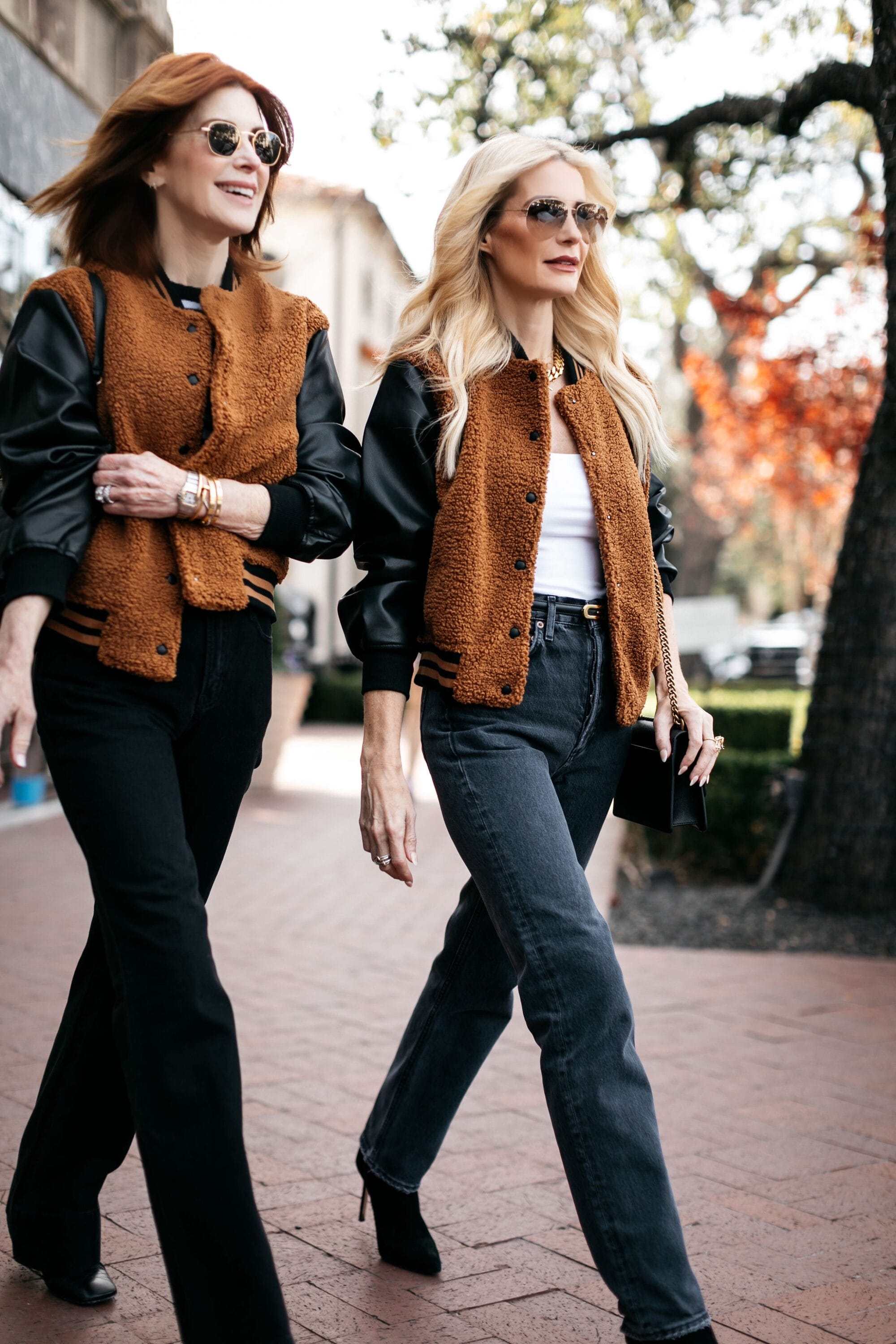 2 over 40 fashion bloggers wearing a varsity bomber jacket with black & blue jeans as one of 5 under $100 jackets.