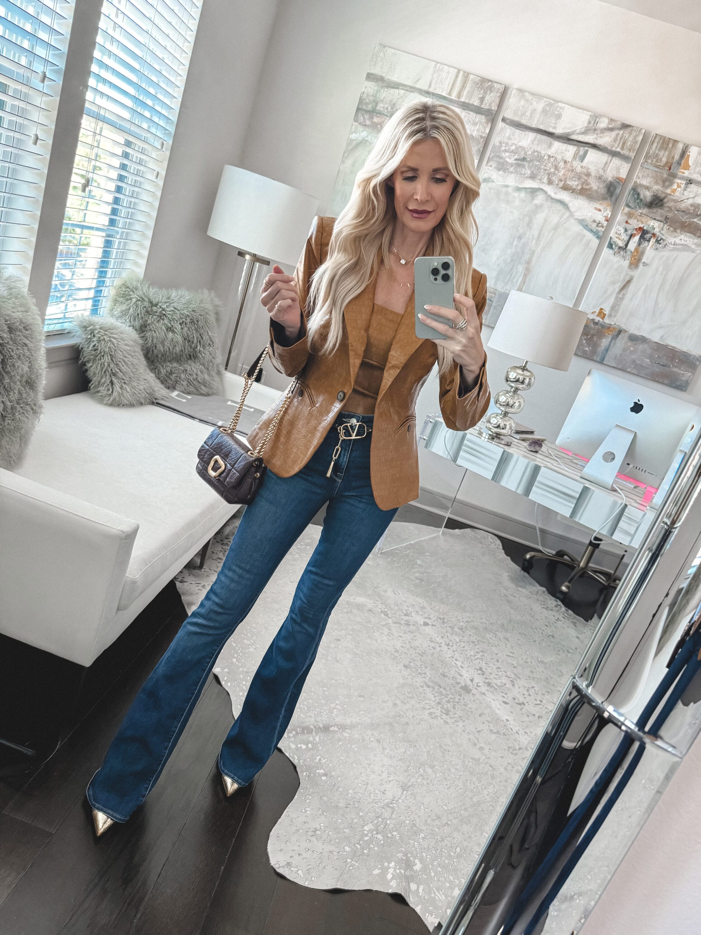 Dallas woman over 40 wearing jeans and a fitted camel blazer with a matching bustier top as one of 5 winter date night looks.
