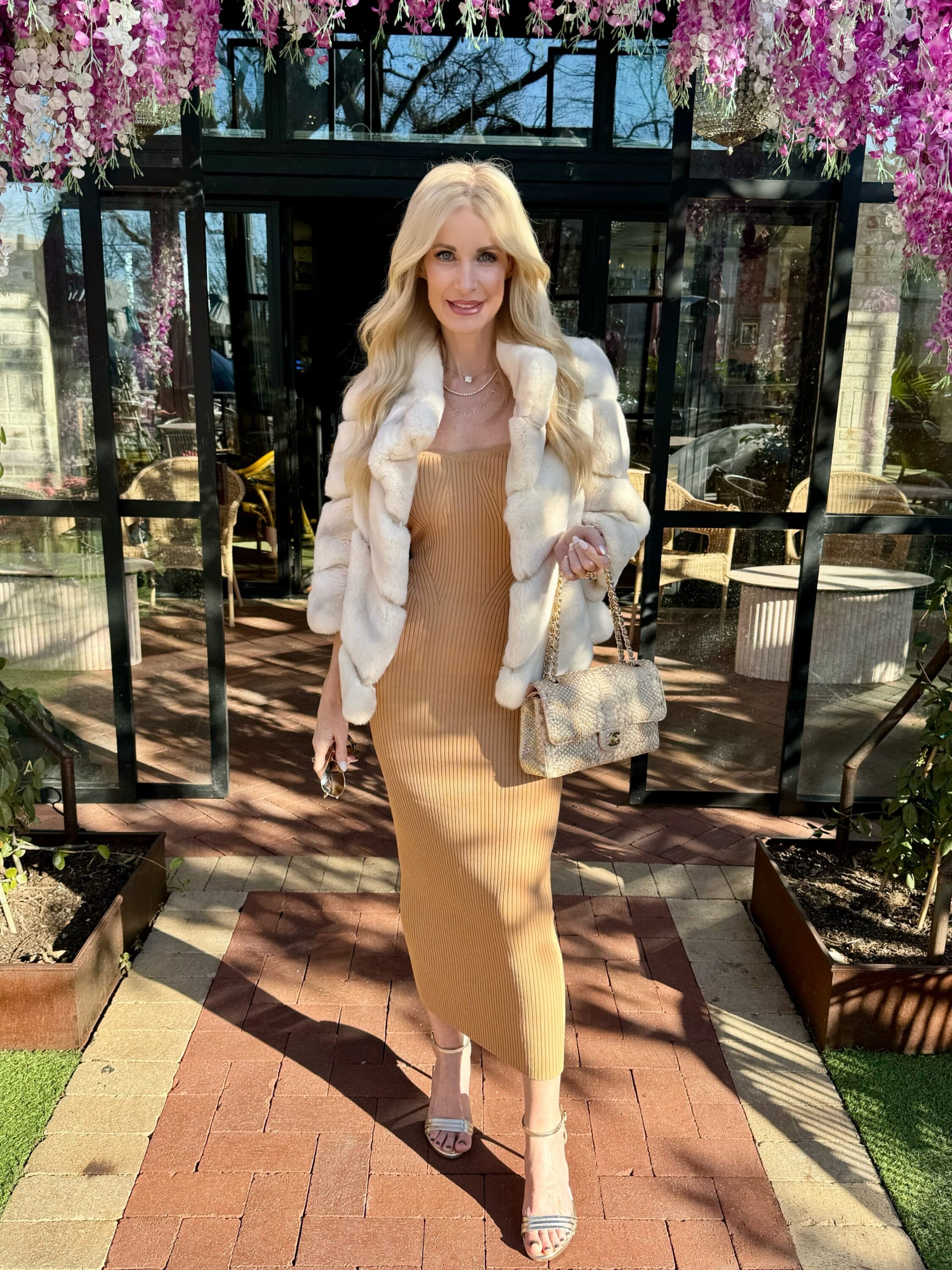 Dallas fashion blogger for women over 40 showcasing a camel dress with a white faux fur jacket as one of 5 mob wife trend looks.