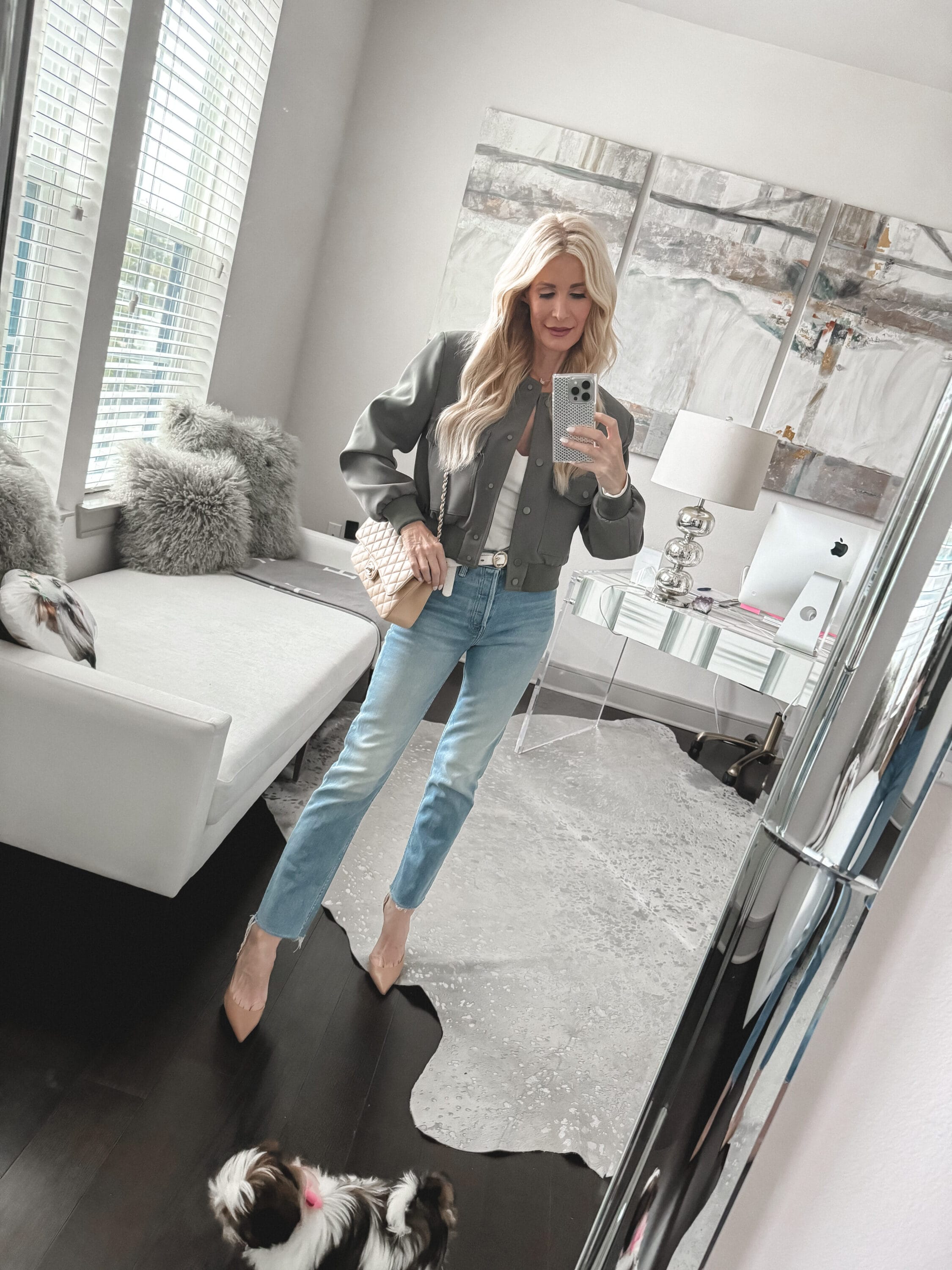 Dallas over 40 fashion stylist wearing a sage green bomber jacket from Mango with frayed edge straight jeans and nude heels as one of 5 ways how to style a bomber jacket in 2024.