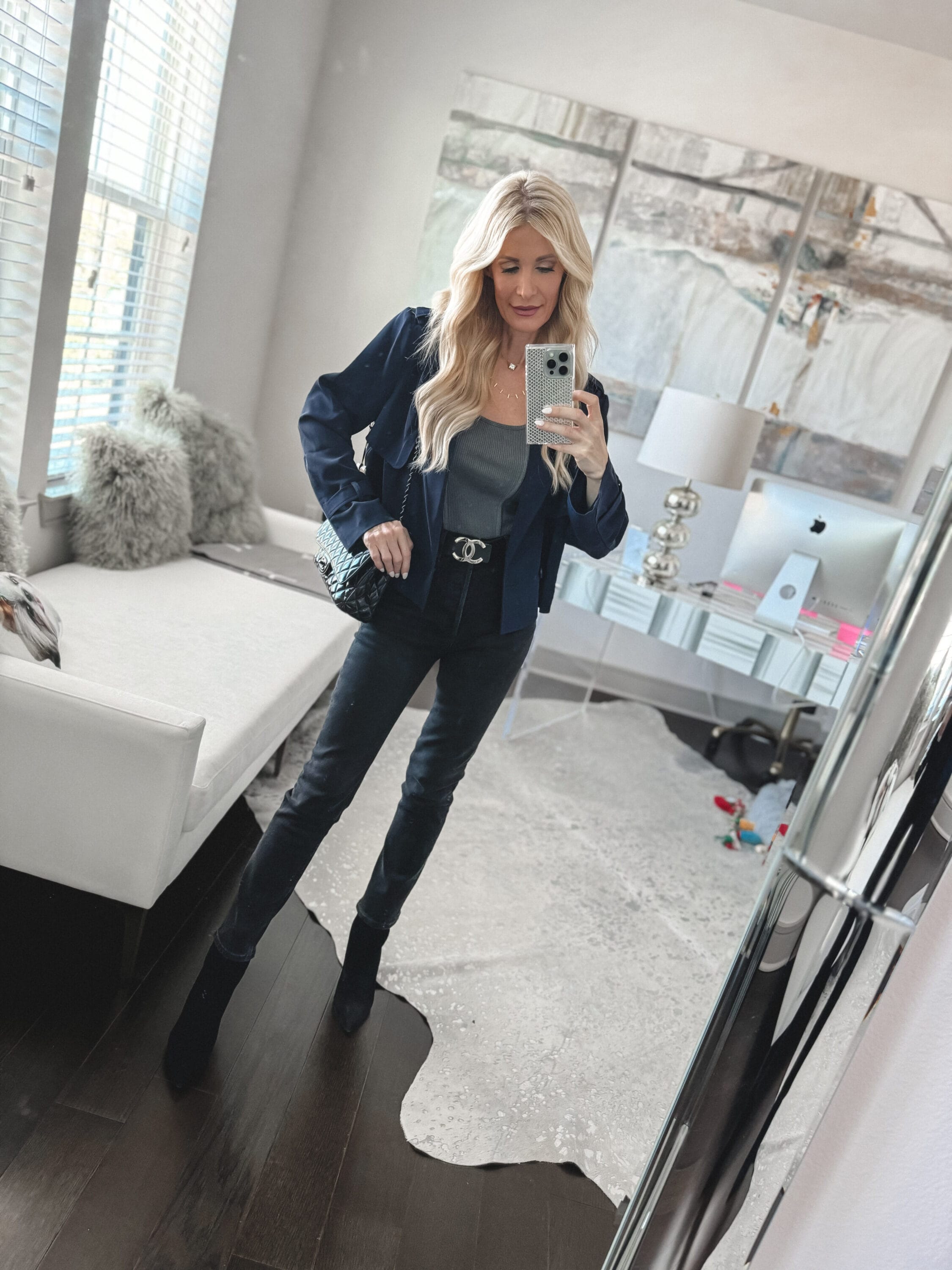 Over 40 fashion blogger wear a navy blazer with black jeans and a grey bodysuit.