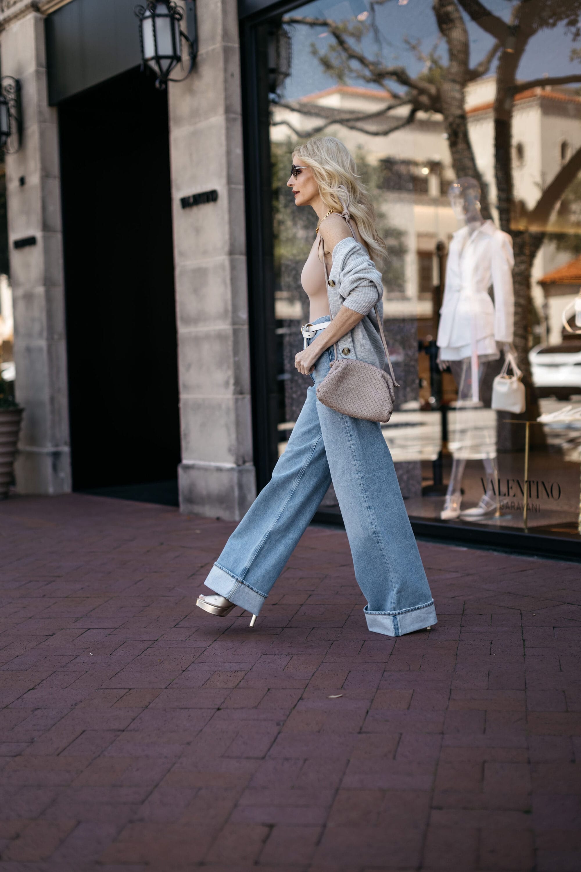 Dallas fashion influencer for women over 40 wearing wide leg jeans and a nude bodysuit with an affordable cashmere cardigan from Quince.