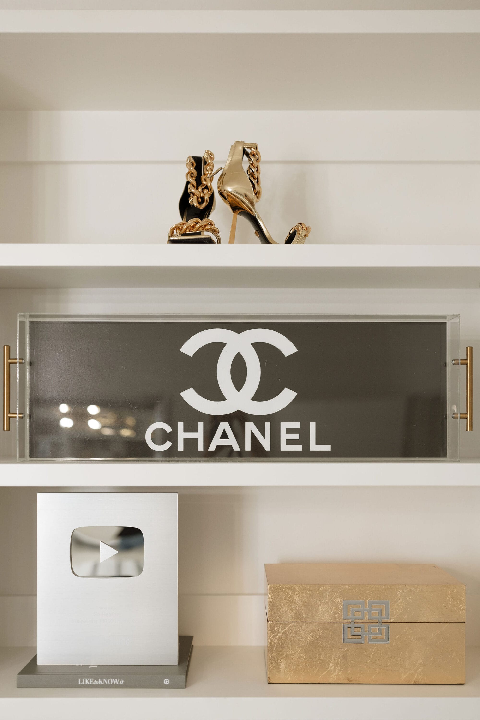 A Chanel serving tray used as home office decor.
