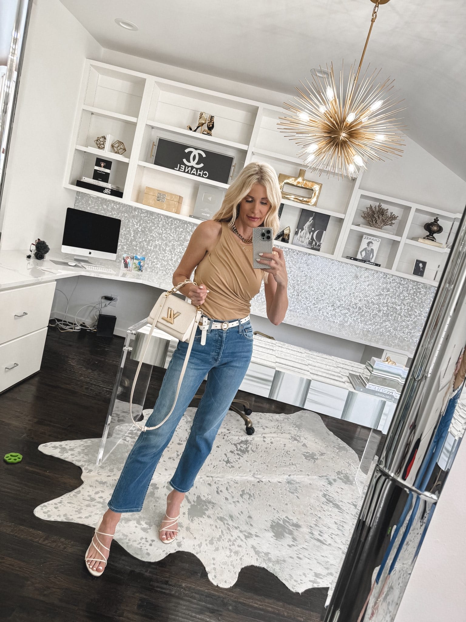 Over 40 fashionista wearing a camel side ruched tank with mother jeans.