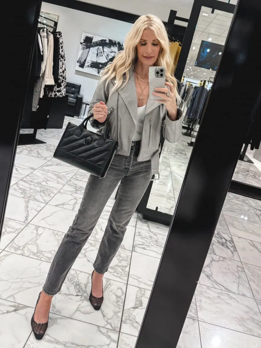 Dallas fashion influencer wearing grey Levi's jeans with a light grey leather jacket, mesh heels and a black handbag as one of 5 ways to style the most versatile style of denim.
