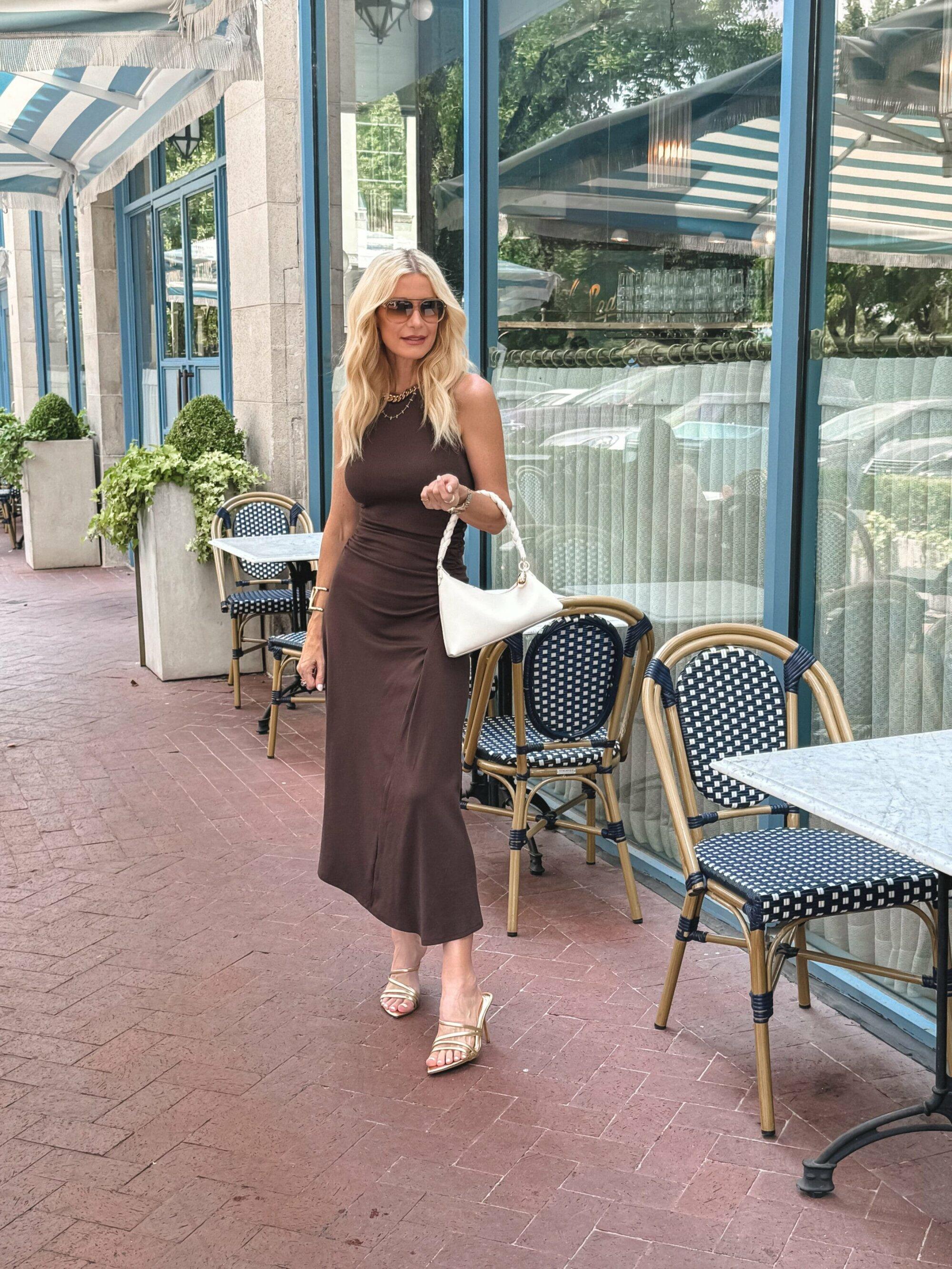 Dallas woman over 40 wearing a brown midi dress with gold accessories as an example of wear now/wear later pieces.