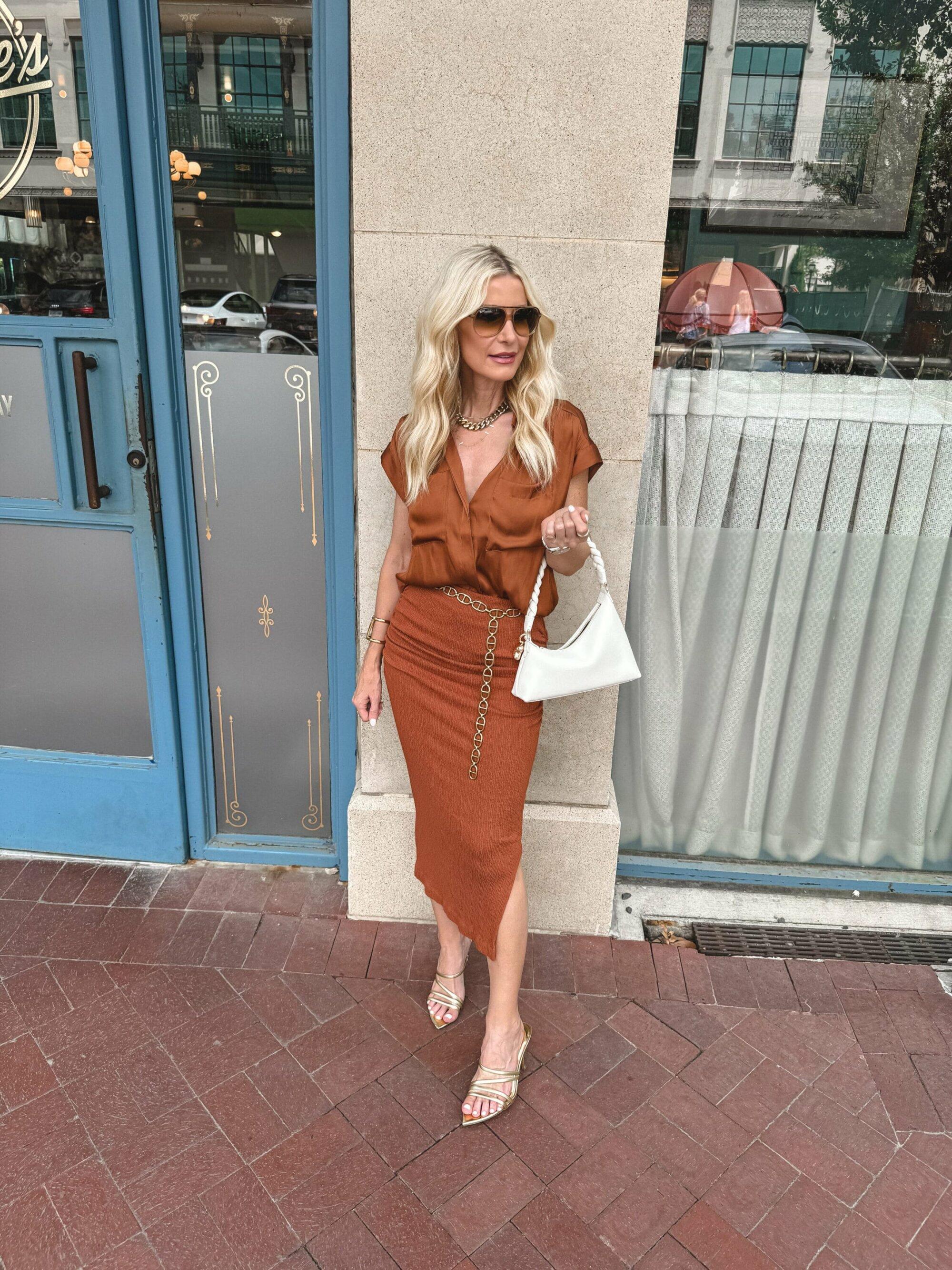Over 40 fashion blogger wearing a rust colored top with a matching midi skirt as 2 transitional pieces for summer to fall.