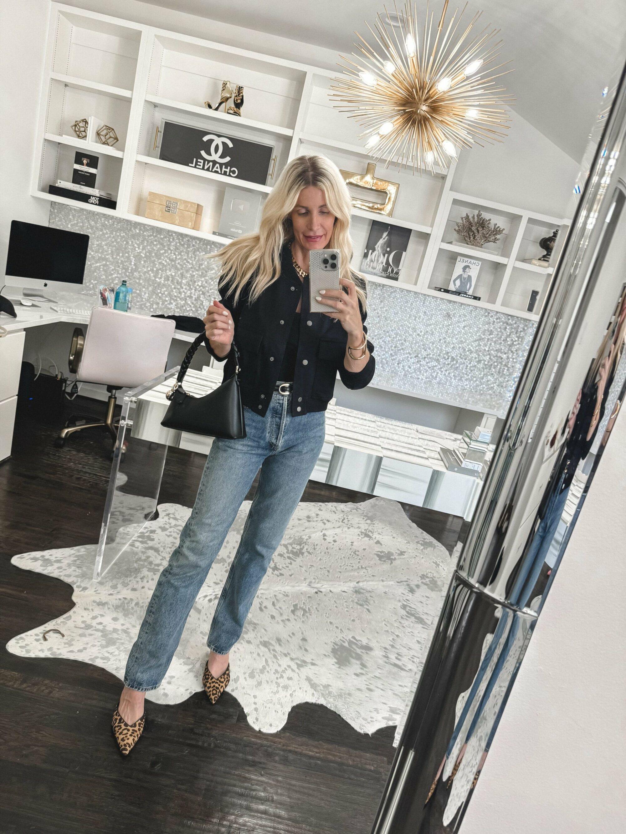 Over 40 fashion stylist showcasing how to style straight leg jeans with a black cotton bomber jacker and leopard print heels.
