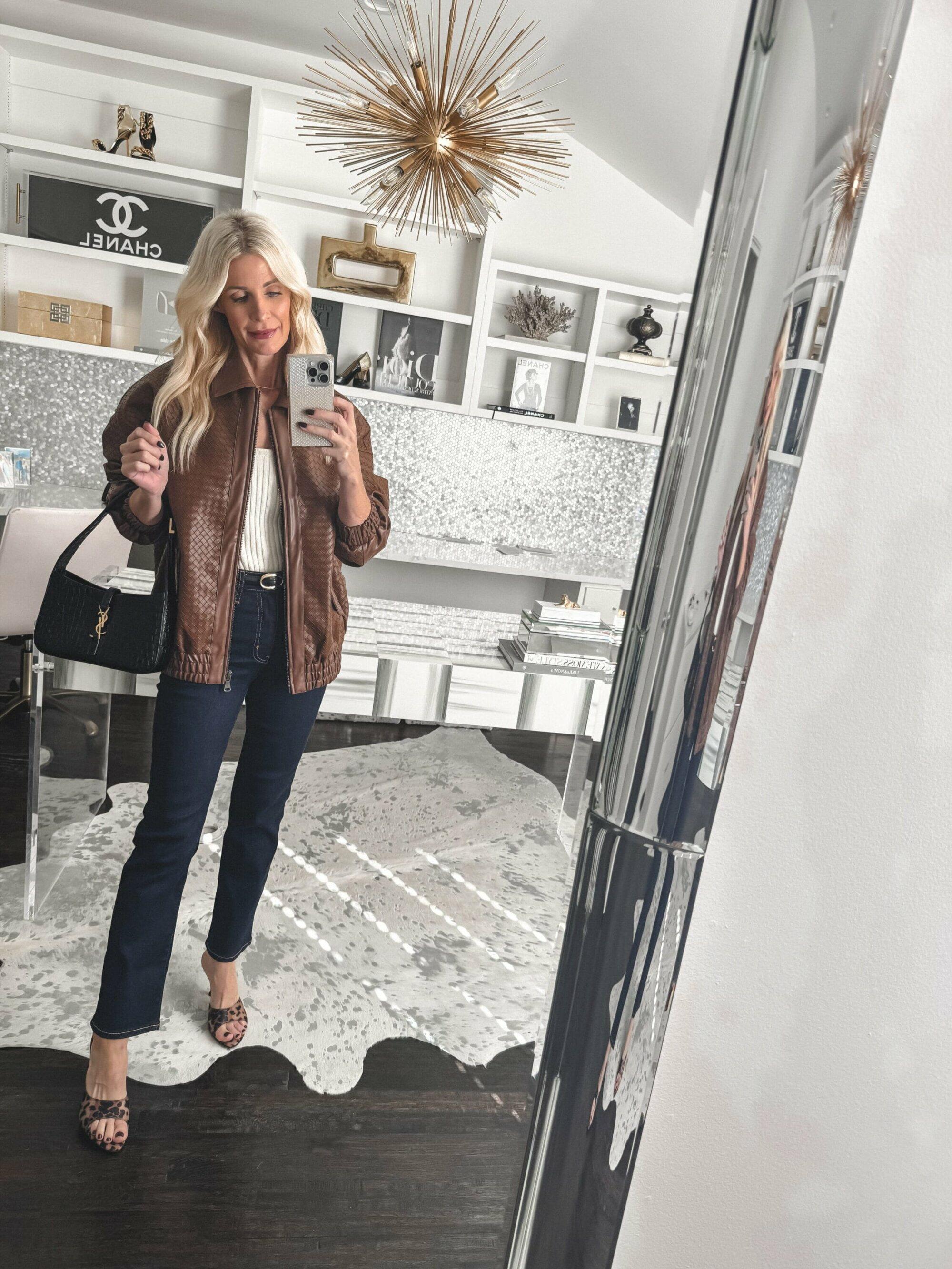 Over 40 Dallas fashion influencer wearing dark was jeans with a textured leather jacket and leopard heels.
