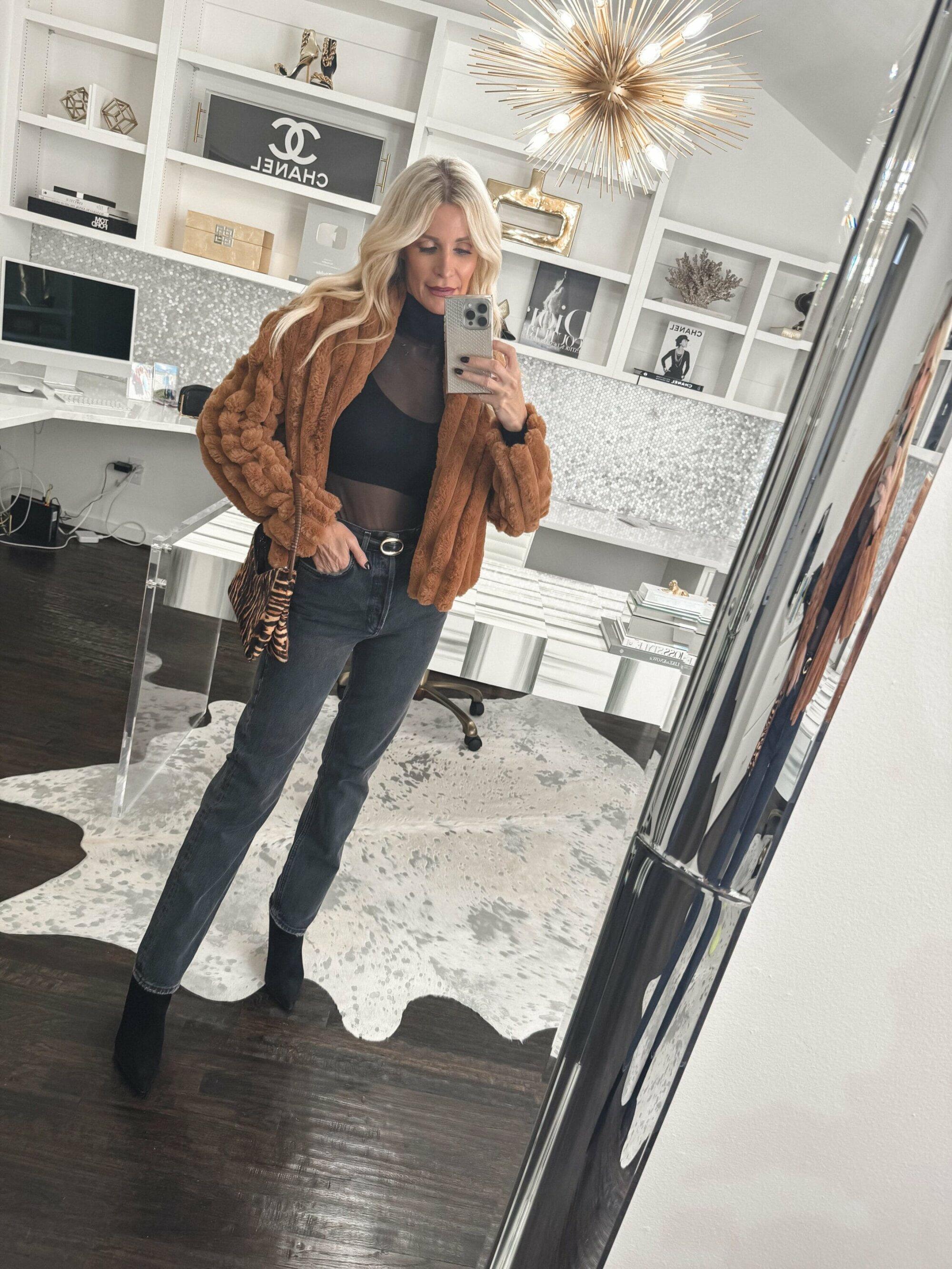 Dallas fashion influencer for women over 40 wearing a light brown ribbed faux fur jacket with faded black wash jeans and black veronica beard booties.