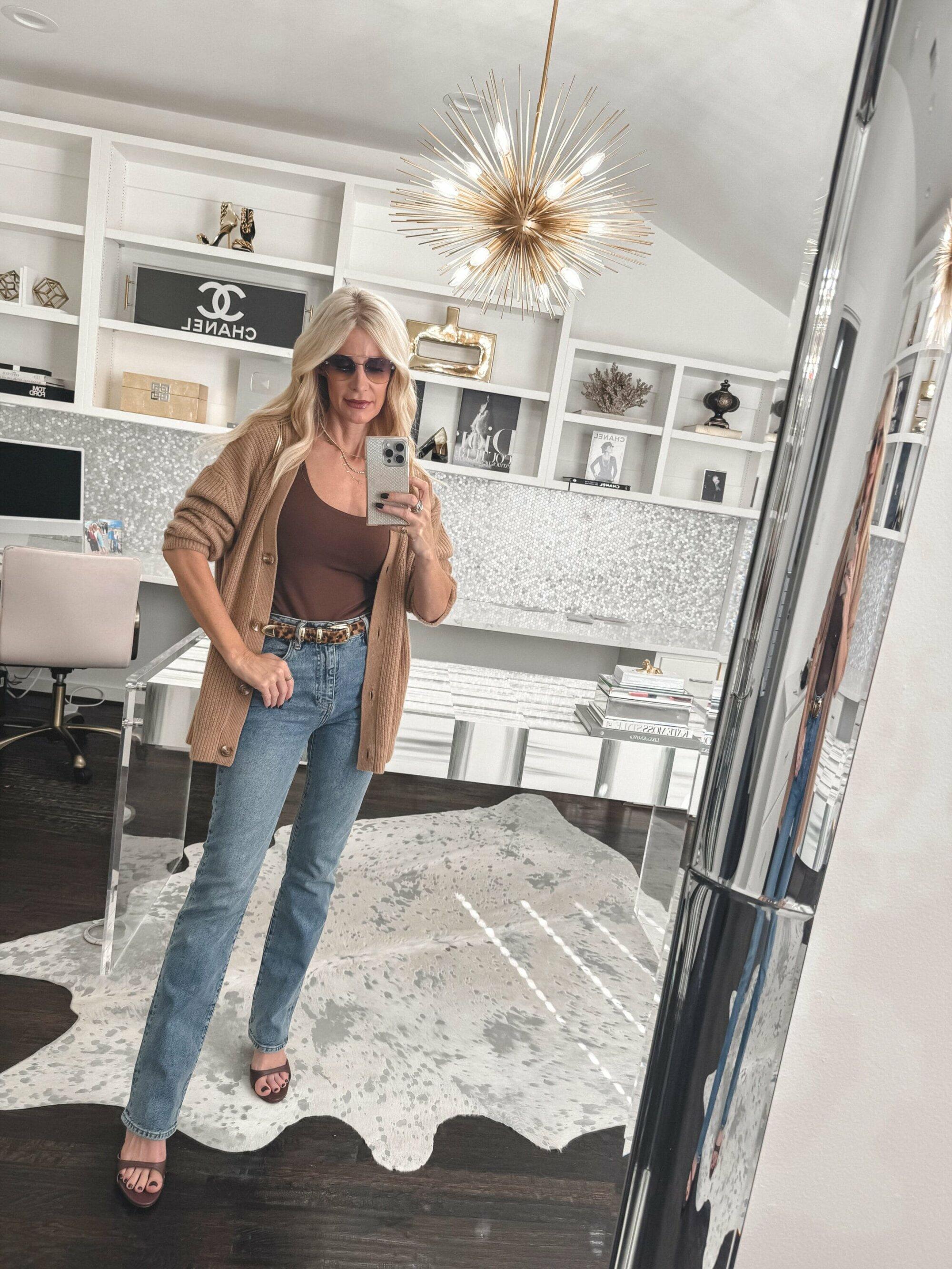 Dallas woman over 40 wearing a camel cardigan with straight leg jeans and a leopard belt.