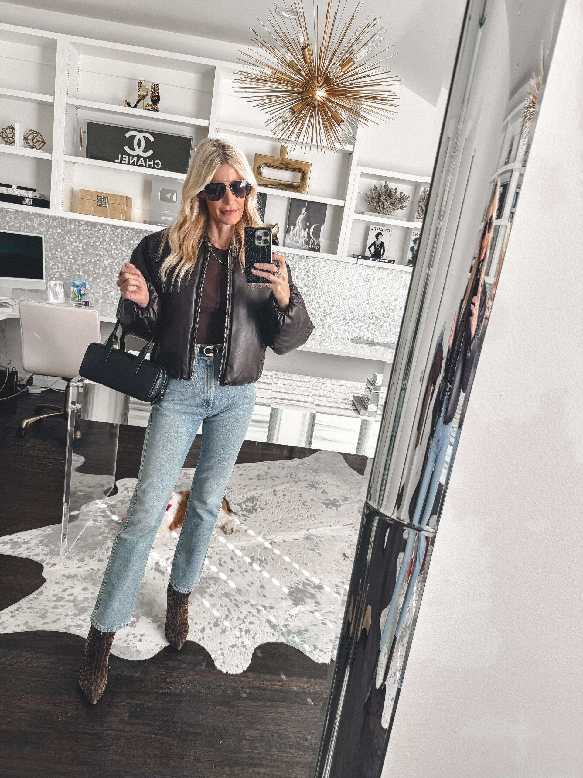 Over 40 Dallas fashion blogger wearing a chocolate brown puffer jacket with light wash jeans and leopard booties as one of hottest color trends of 2025.