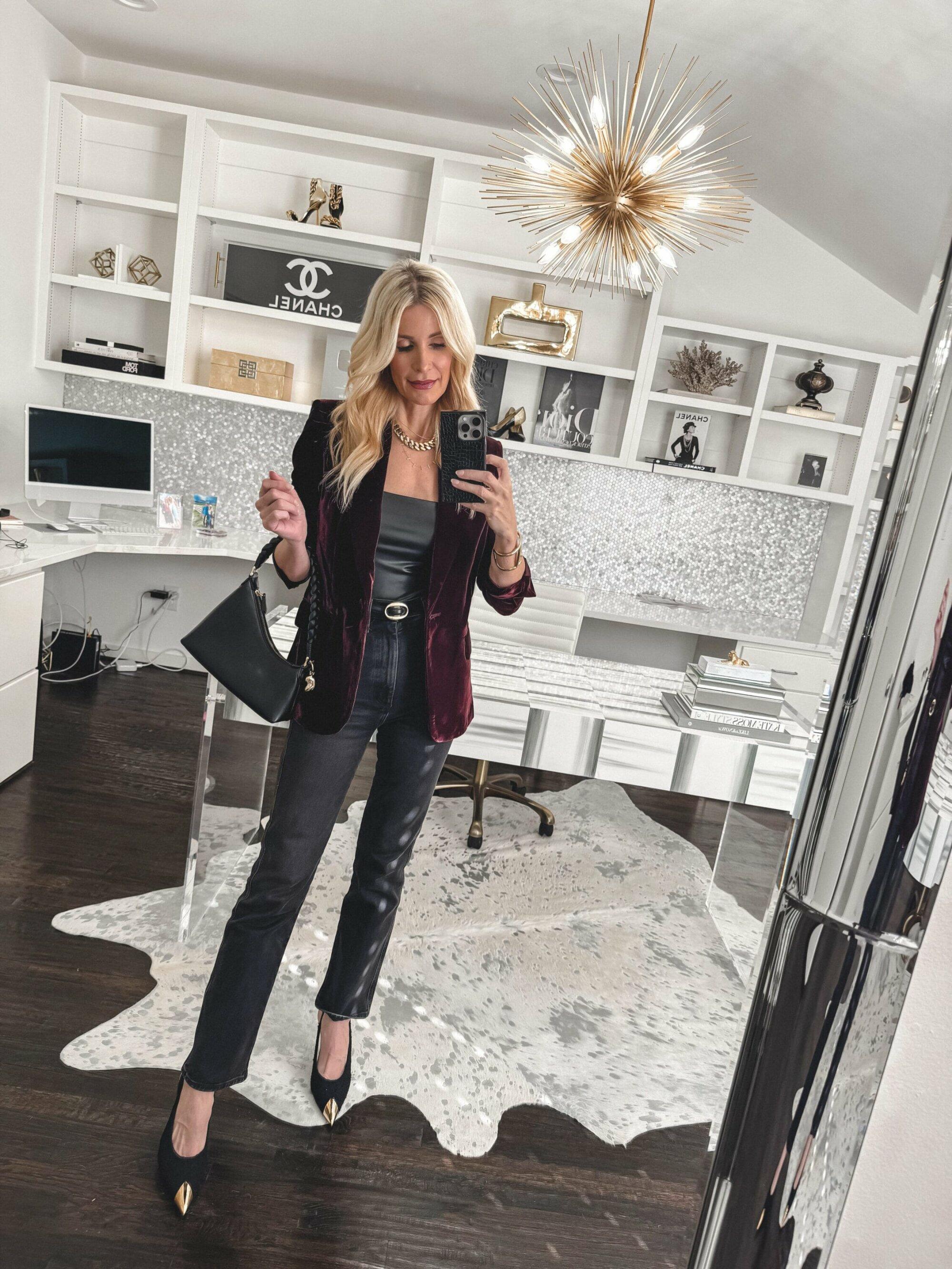 Over 40 fashion blogger wearing a velvet blazer and faux leather bodysuit with black jeans and gold tipped heels.