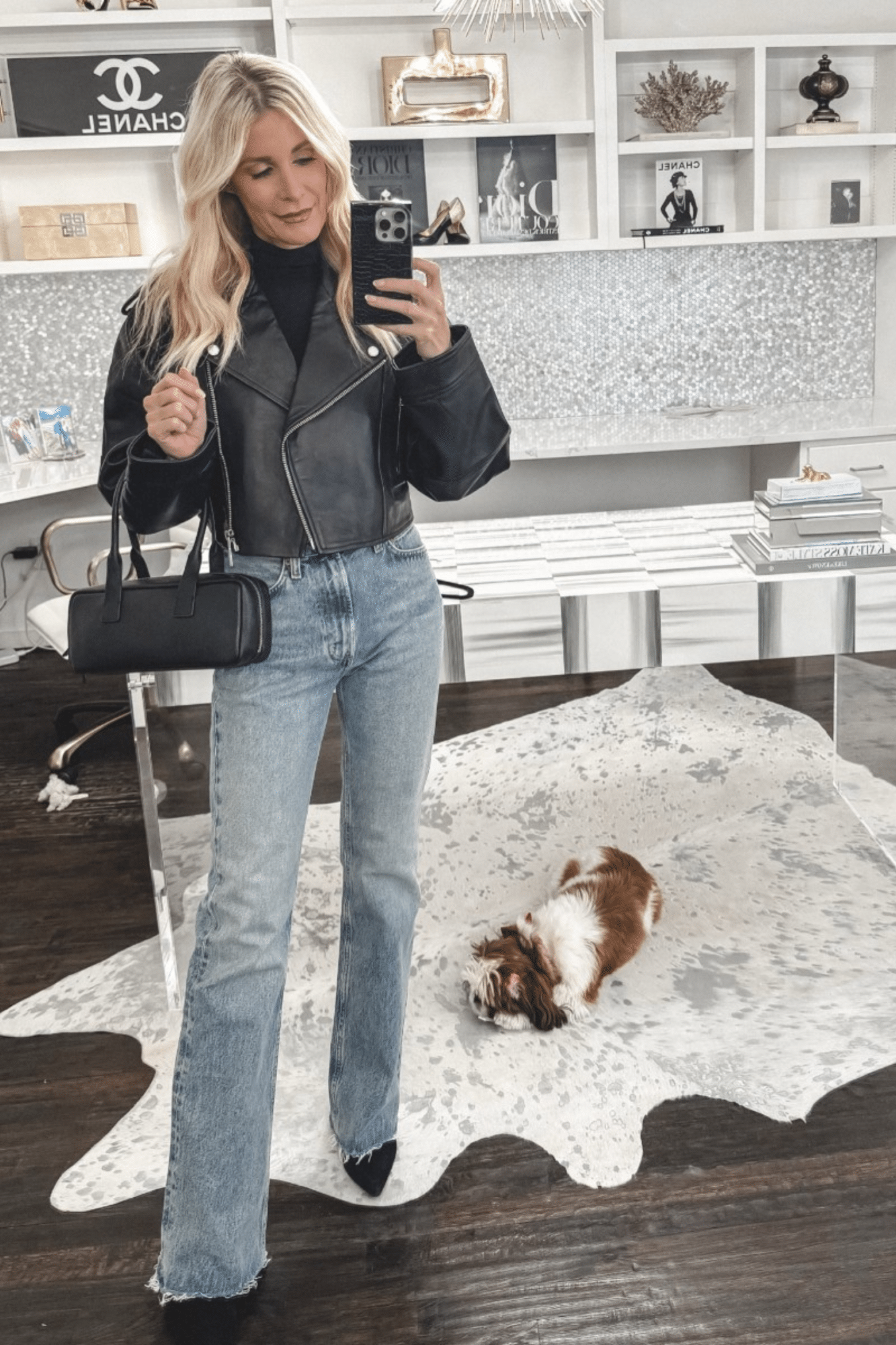 Dallas fashion stylist for women over 40 wearing a pair of baby flare jeans with a cropped leather jacket and east west handbag.